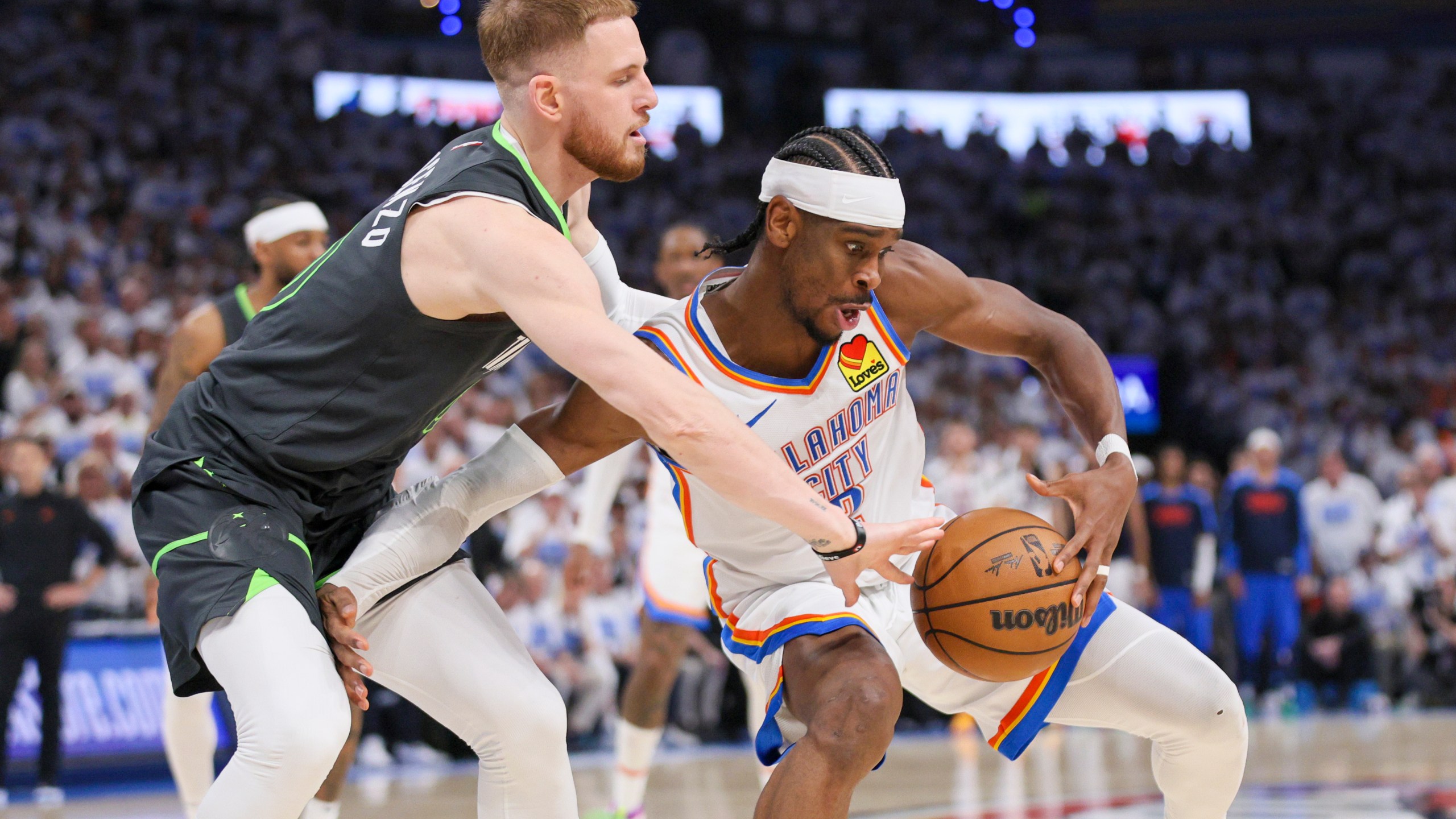 Minnesota Timberwolves guard Donte DiVincenzo, left, applies pressure on Oklahoma City Thunder guard Shai Gilgeous-Alexander during the second half of Game 1 of an NBA basketball Western Conference Finals playoff series Tuesday, May 20, 2025, in Oklahoma City. (AP Photo/Nate Billings)