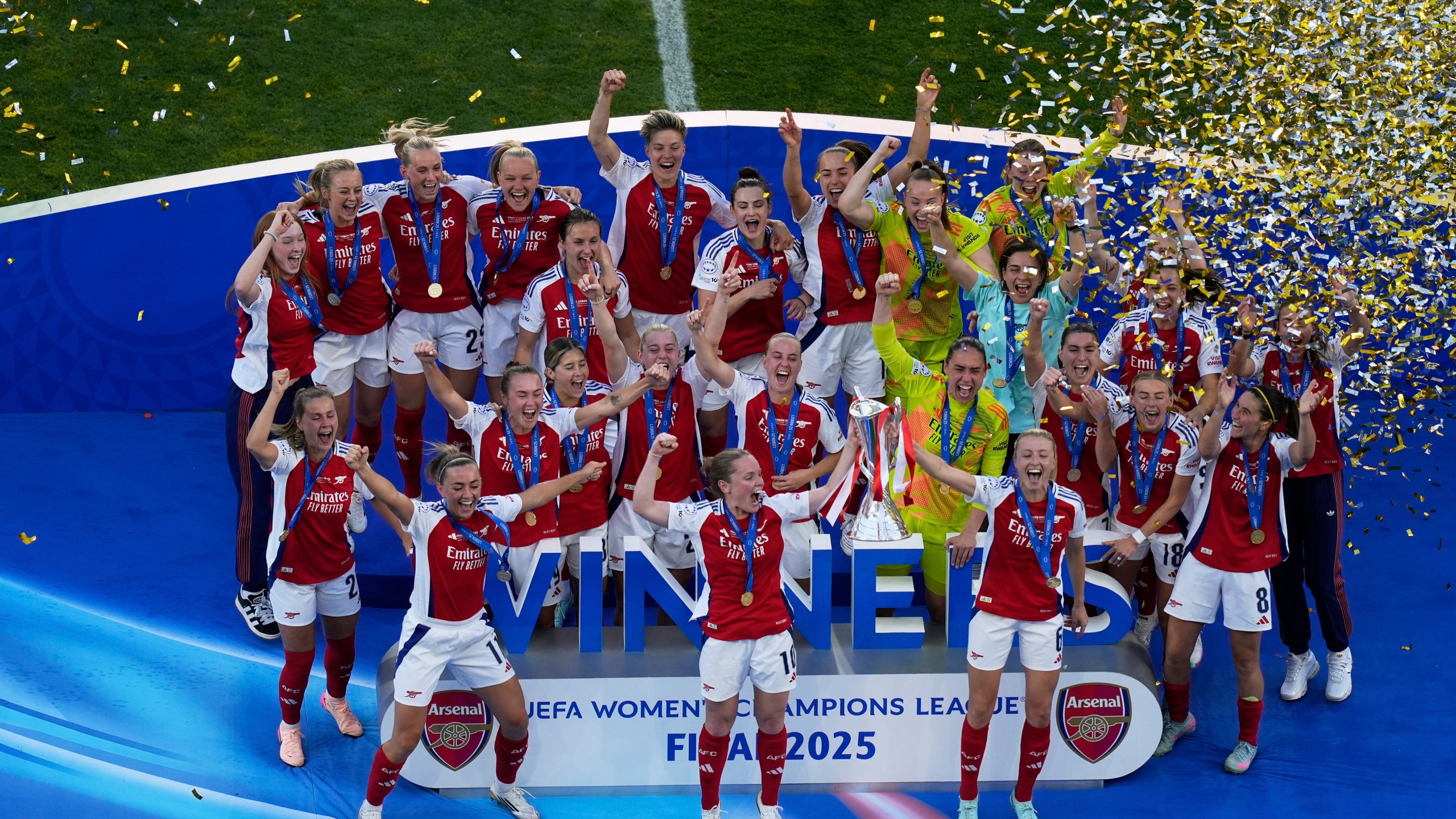 Arsenal's Kim Little, centre, holds the trophy as she celebrates with her teammates after winning the women's Champions League final soccer match between Arsenal and FC Barcelona at the Jose Alvalade Stadium in Lisbon, Saturday, May 24, 2025. (AP Photo/Ana Brigida)