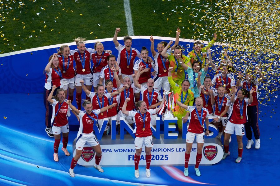 Arsenal's Kim Little, centre, holds the trophy as she celebrates with her teammates after winning the women's Champions League final soccer match between Arsenal and FC Barcelona at the Jose Alvalade Stadium in Lisbon, Saturday, May 24, 2025. (AP Photo/Ana Brigida)
