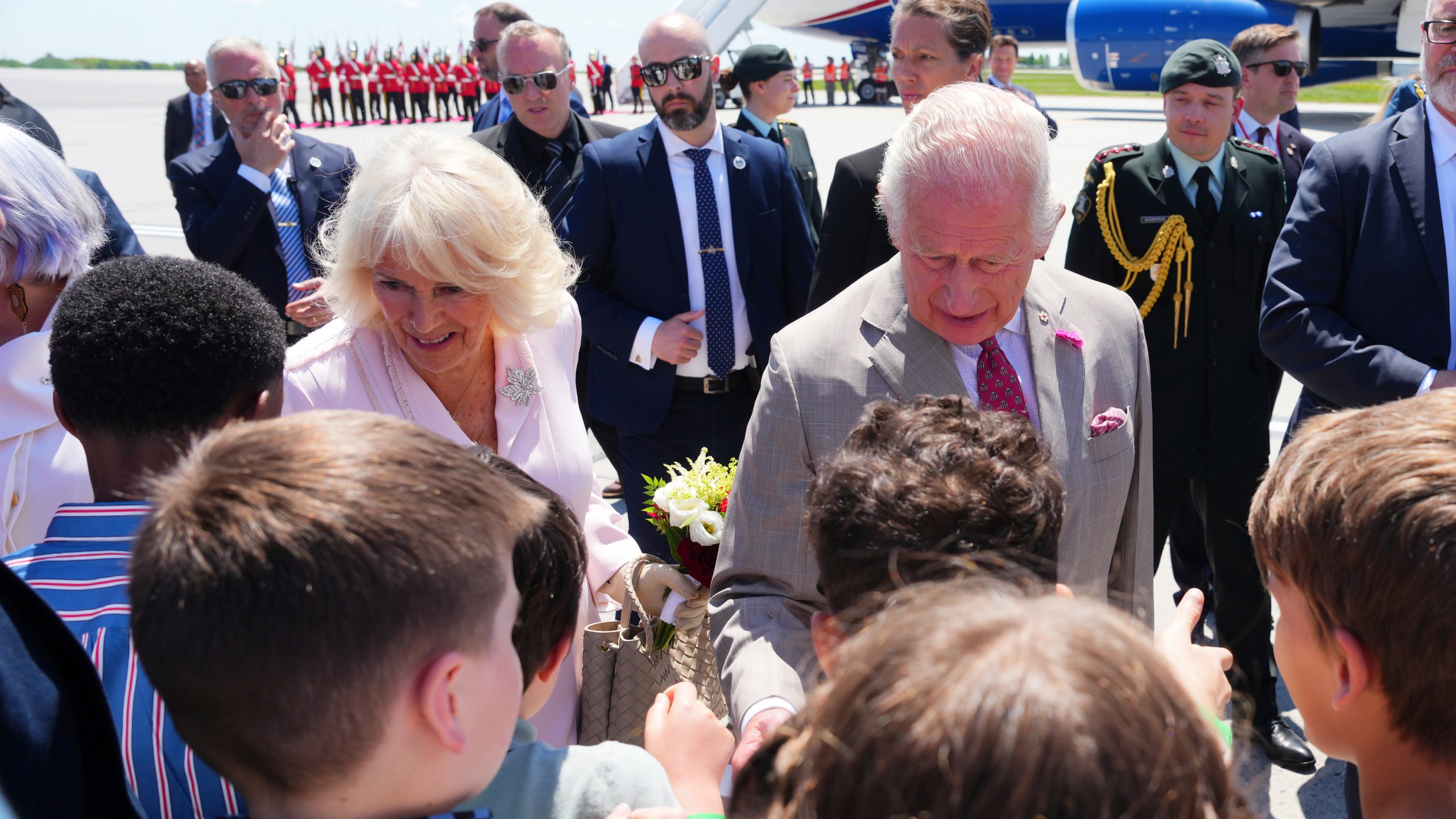 King Charles and Queen Camilla greet school children as they arrive at the Ottawa International Airport in Ottawa, Canada, for a royal visit on Monday, May 26, 2025. (Sean Kilpatrick/The Canadian Press via AP)