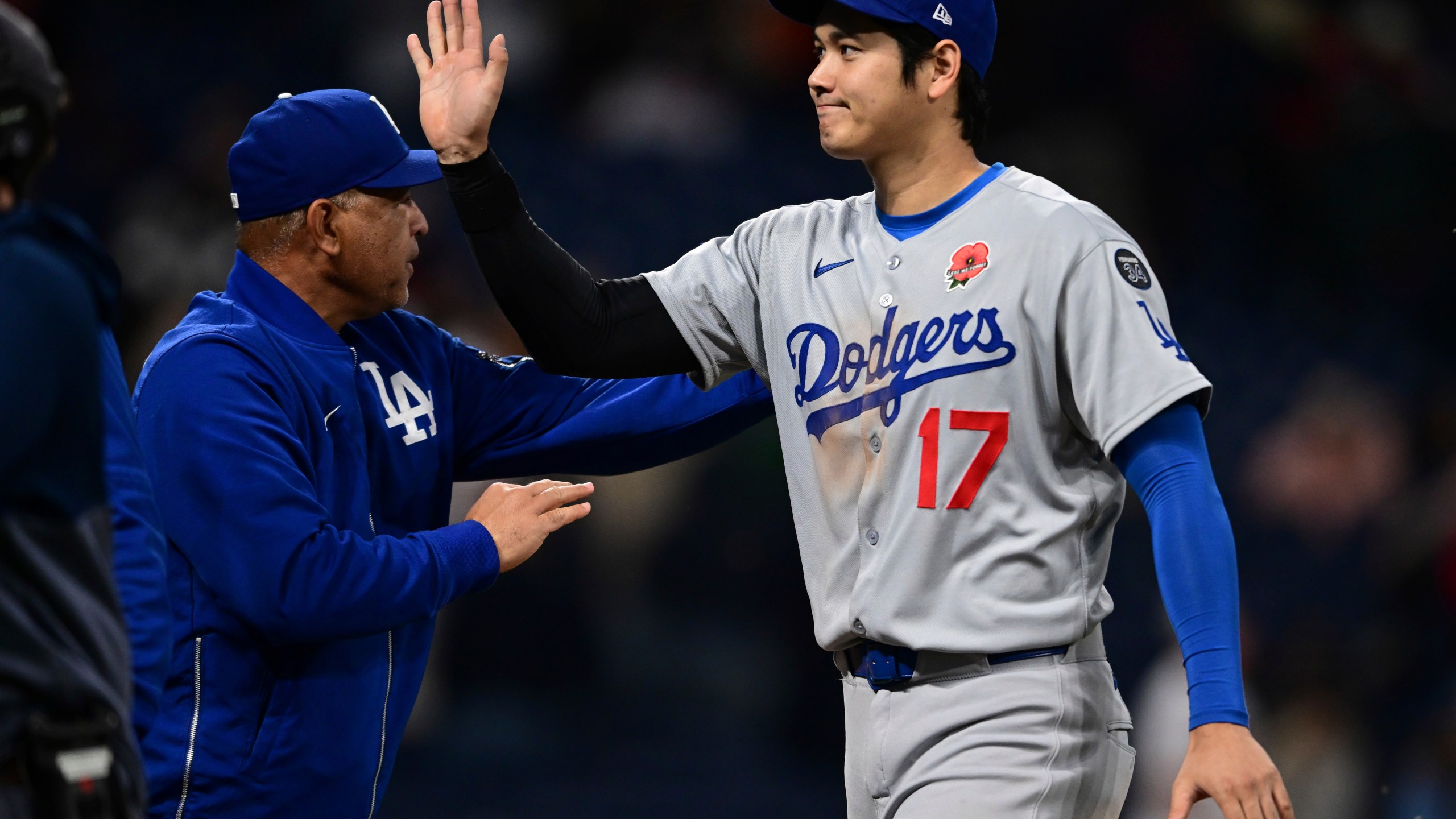 Los Angeles Dodgers' Shohei Ohtani (17) is congratulated by manager Dave Roberts, left, after the team defeated the Cleveland Guardians in a baseball game, Monday, May 26, 2025, in Cleveland. (AP Photo/David Dermer)