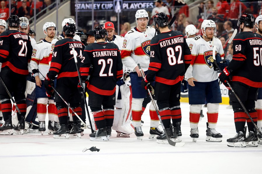 The Florida Panthers shake hands with the Carolina Hurricanes following Florida's win in Game 5 of the NHL hockey Stanley Cup Eastern Conference finals in Raleigh, N.C., Wednesday, May 28, 2025. (AP Photo/Karl DeBlaker)