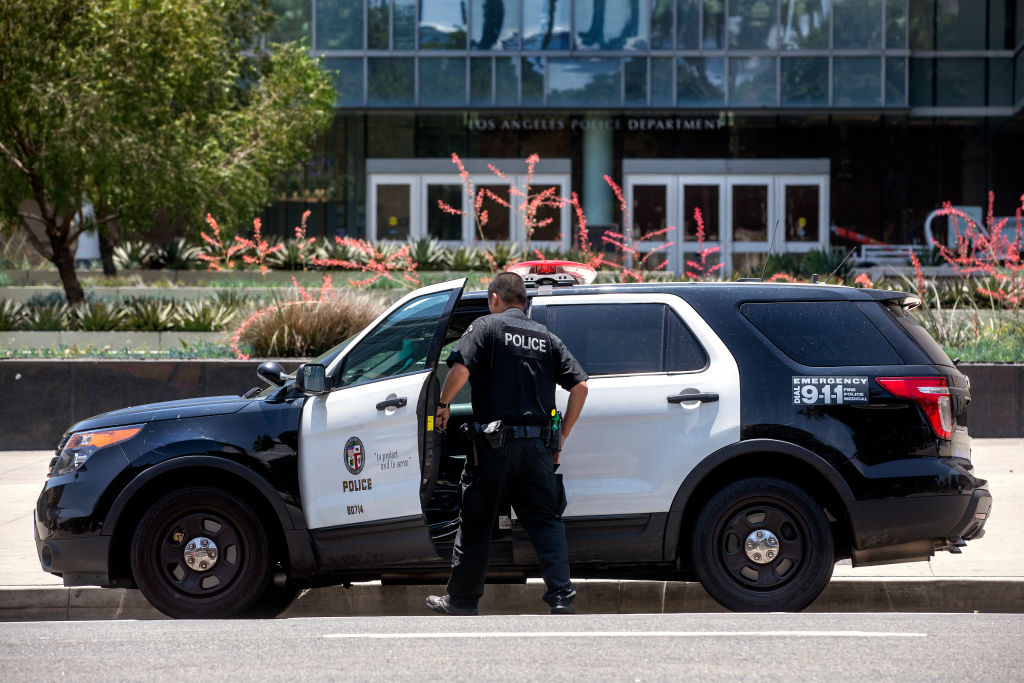 An LAPD officer gets into his patrol car in front of LAPD Headquarters on 1st St. in downtown Los Angeles. (Mel Melcon / Los Angeles Times via Getty Images)