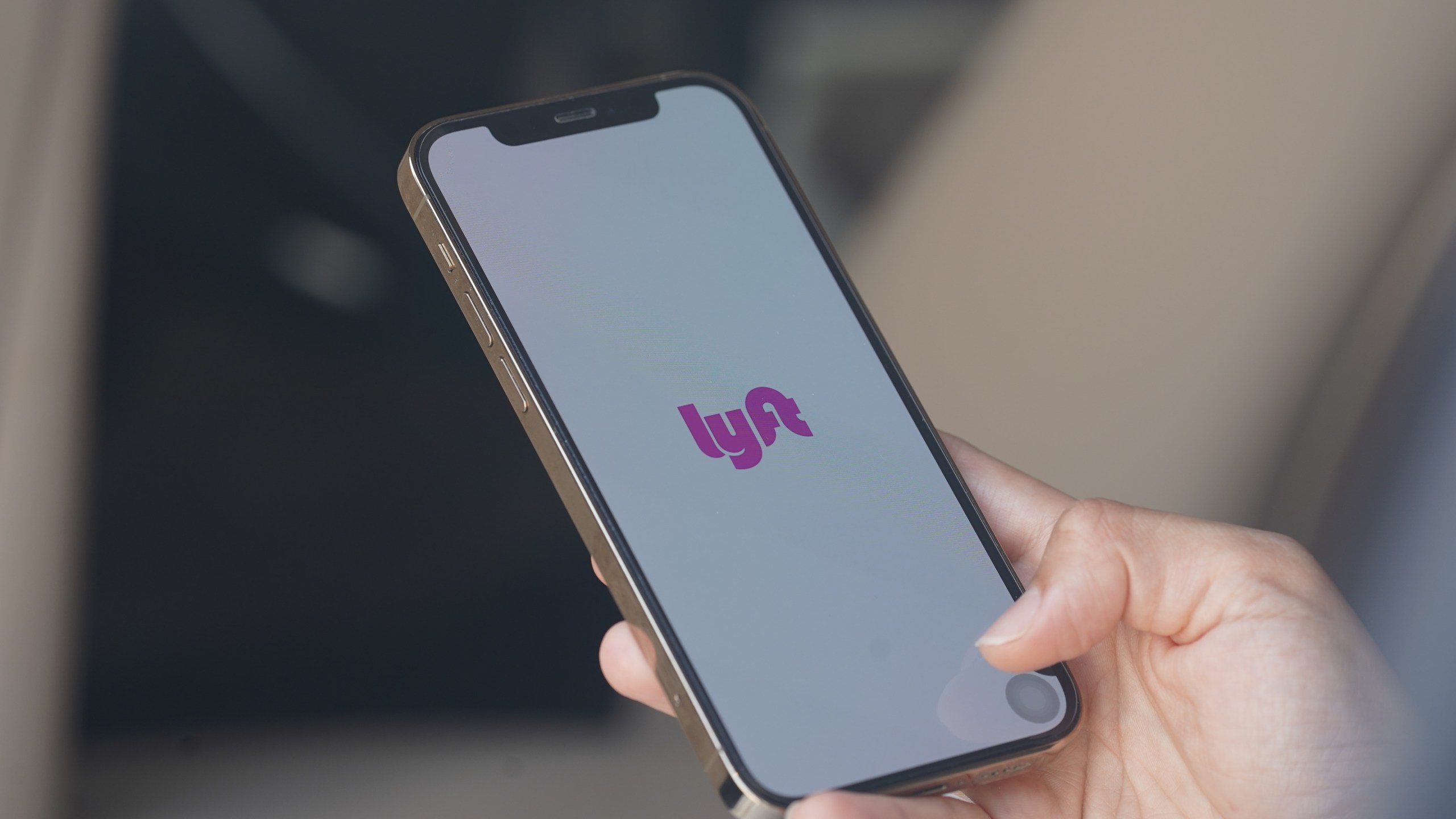 In this photo illustration, a woman browses the Lyft app on her smartphone. (Getty Images)