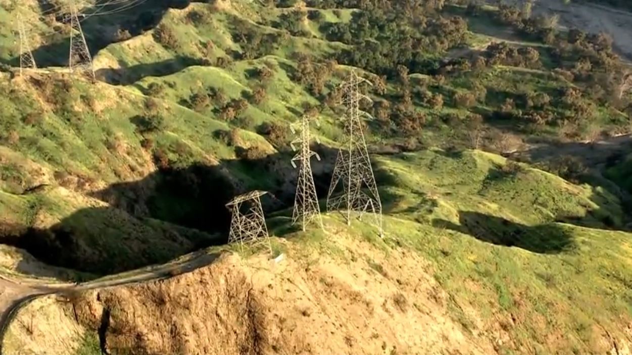 One of two Southern California Edison transmission towers (on left) was dismantled and removed from the site on May 7, 2025, as part of an investigation into whether the towers played a role in the deadly Eaton fire in Altadena. (KTLA)