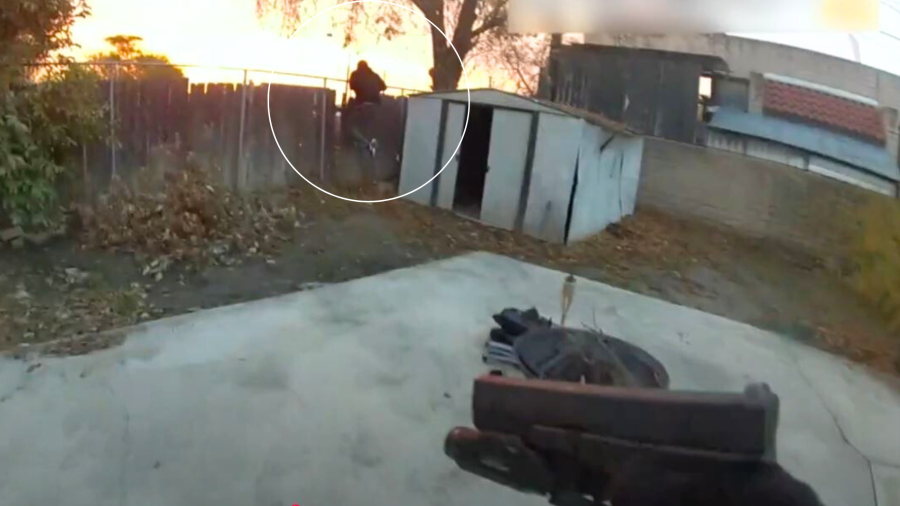 Rober Brown is seen climbing over a fence into a nearby home in San Bernardino as a police officer chases after him on Dec. 27, 2023. (San Bernardino Police Department)