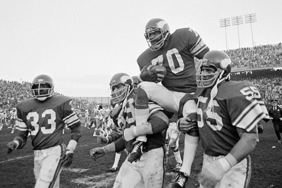 FILE - Minnesota Viking tackle Jim Marshall clutches the game ball as he is carried from the field by teammates Doug Southerland, left, and Scott Studwell after the Vikings defeated the Buffalo Bills 10-3 in an NFL football game in Bloomington, Minn., on Sunday, Dec. 9, 1979. (AP Photo/Jim Mone, File)
