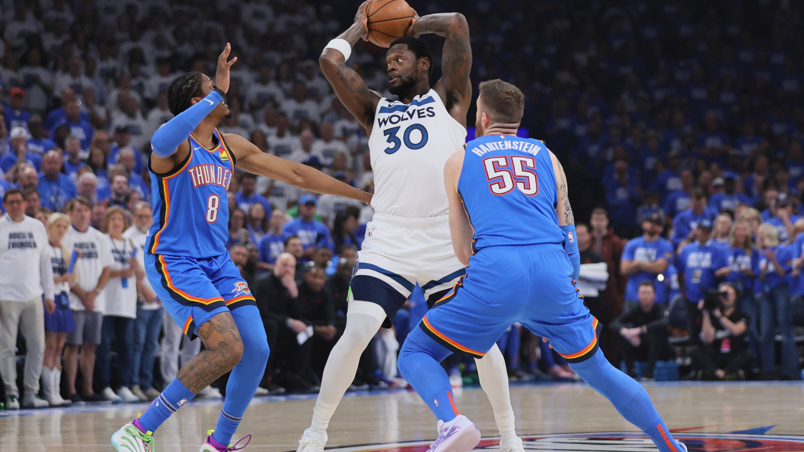 Minnesota Timberwolves forward Julius Randle (30) looks to pass as Oklahoma City Thunder forward Jalen Williams (8) and center Isaiah Hartenstein (55) defend during the first half of Game 5 of the Western Conference finals of the NBA basketball playoffs, Wednesday, May 28, 2025, in Oklahoma City. (AP Photo/Nate Billings)