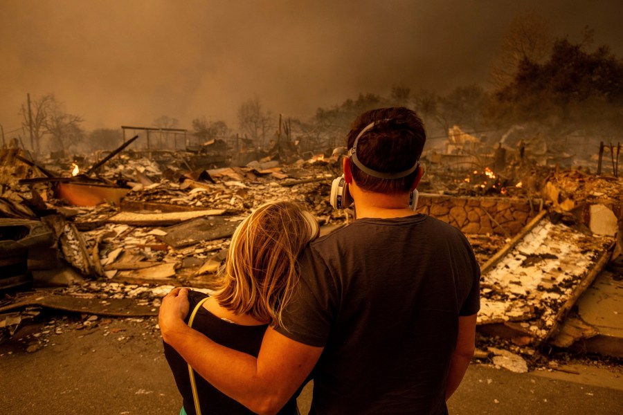 FILE - Megan Mantia, left, and her boyfriend Thomas, only first game given, return to Mantia's fire-damaged home after the Eaton Fire swept through the area, Jan. 8, 2025, in Altadena, Calif. (AP Photo/Ethan Swope, File)