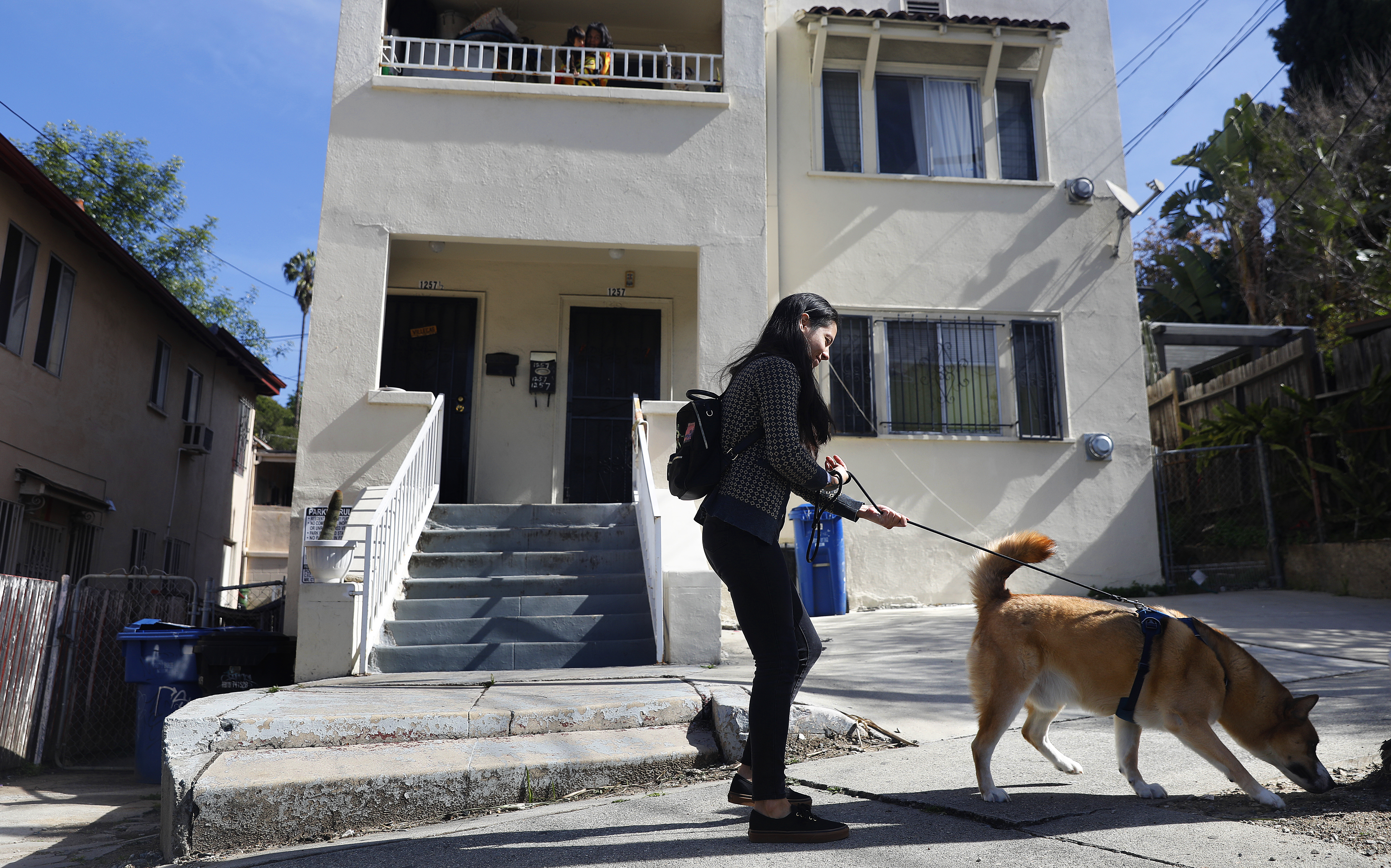 A woman walks her dog past apartment complexes on Vin Scully Avenue in Elysian Park, Los Angeles on March 27, 2023. (Getty Images)