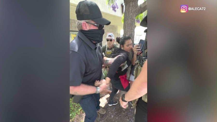 A street food vendor clings onto a tree before she was detained by immigration agents in Ladera Heights on June 23, 2025. Bystanders were yelling at the agents to identify themselves.  (@aleca72)