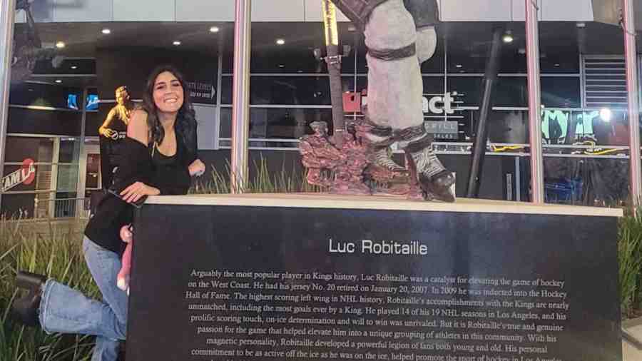 Jessica McLaughlin poses next to the Los Angeles Kings Luc Robitaille statue outside Crypto.com Arena in this undated photo provided by family. (GoFundMe)