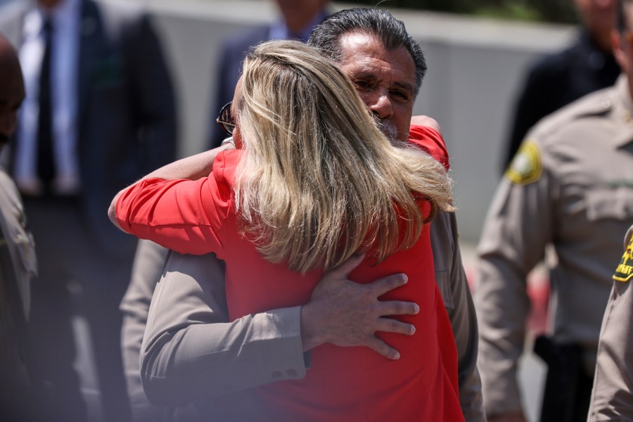 Los Angeles County Sheriff Robert Luna gets a hug from Supervisor Kathryn Barger as he arrives for a press conference after three members of the department were killed in an explosion at a training facility on Friday, July 18, 2025, in Los Angeles. (AP Photo/Etienne Laurent)
