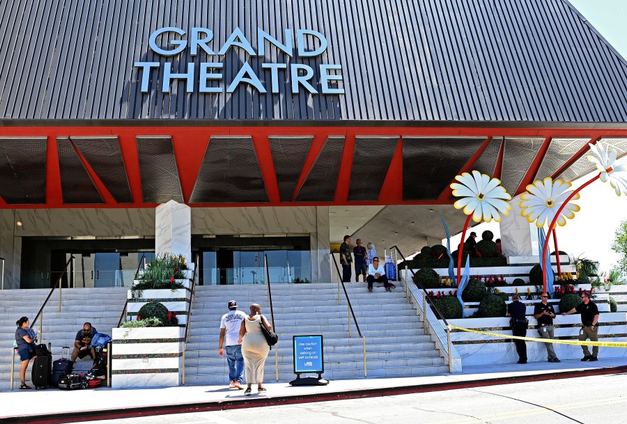 Police stand on the right of an entrance to the Grand Sierra Resort as guests arrive at the resort where a shooting occurred in Reno, Nev., Monday, July 28, 2025. (AP Photo/Andy Barron)