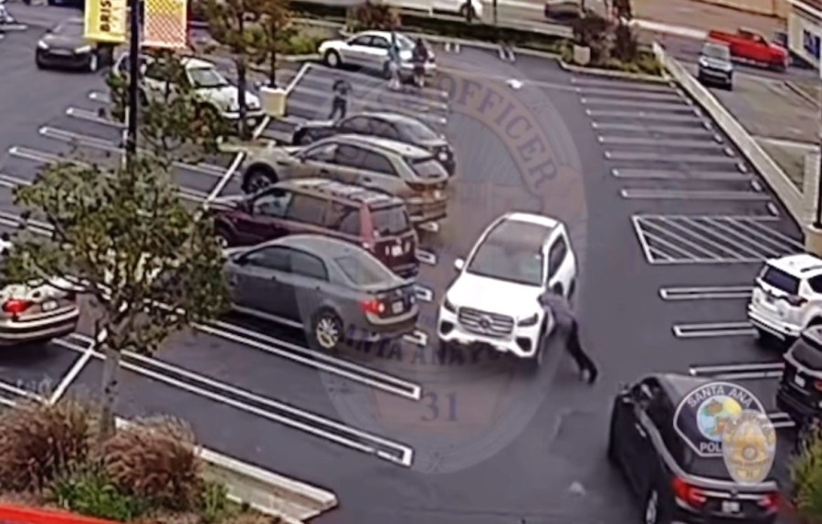 Surveillance video showed the victim trying to stop the robbery suspects from fleeing in a Mercedes GLS 450 SUV before he was run over on June 4, 2025. (Santa Ana Police Department)