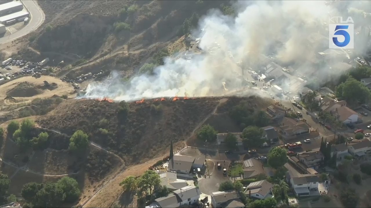 Firefighters battled a grass fire that ignited on a hillside near homes in Pacoima on July 11, 2025. (KTLA)