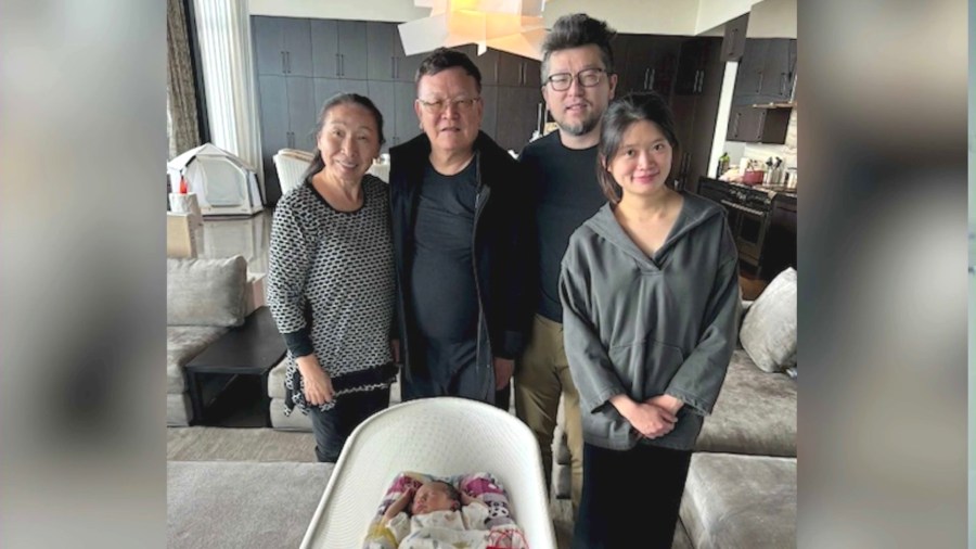 Naiping Hou, 74, second from left, is seen with his family and infant grandchild. (Hou Family)