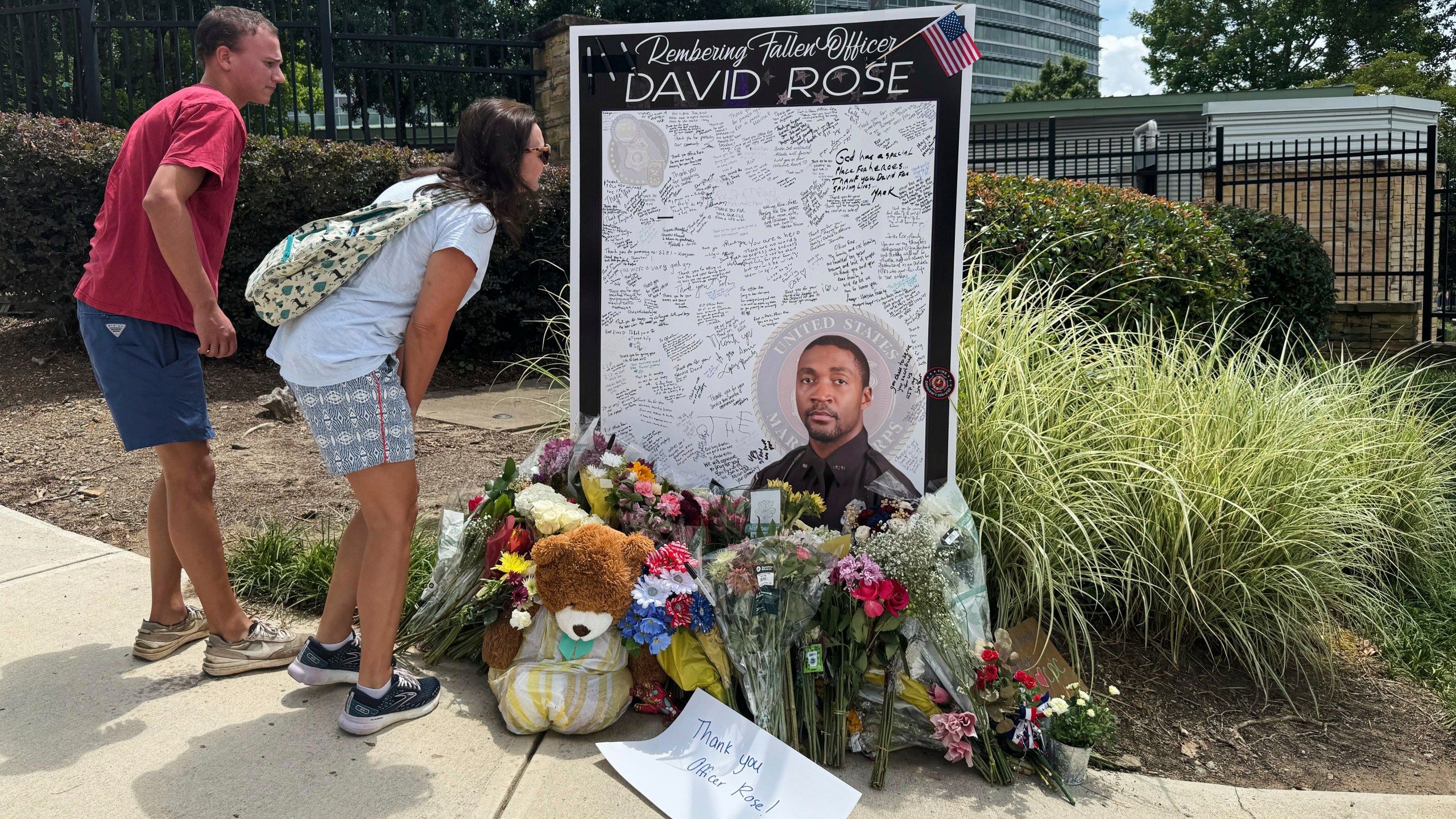 People leave flowers Monday, Aug. 11, 2025, at a makeshift memorial in honor of David Rose, the officer who was killed in the shooting at the U.S. Centers for Disease Control and Prevention headquarters in Atlanta. (AP Photo/Charlotte Kramon)