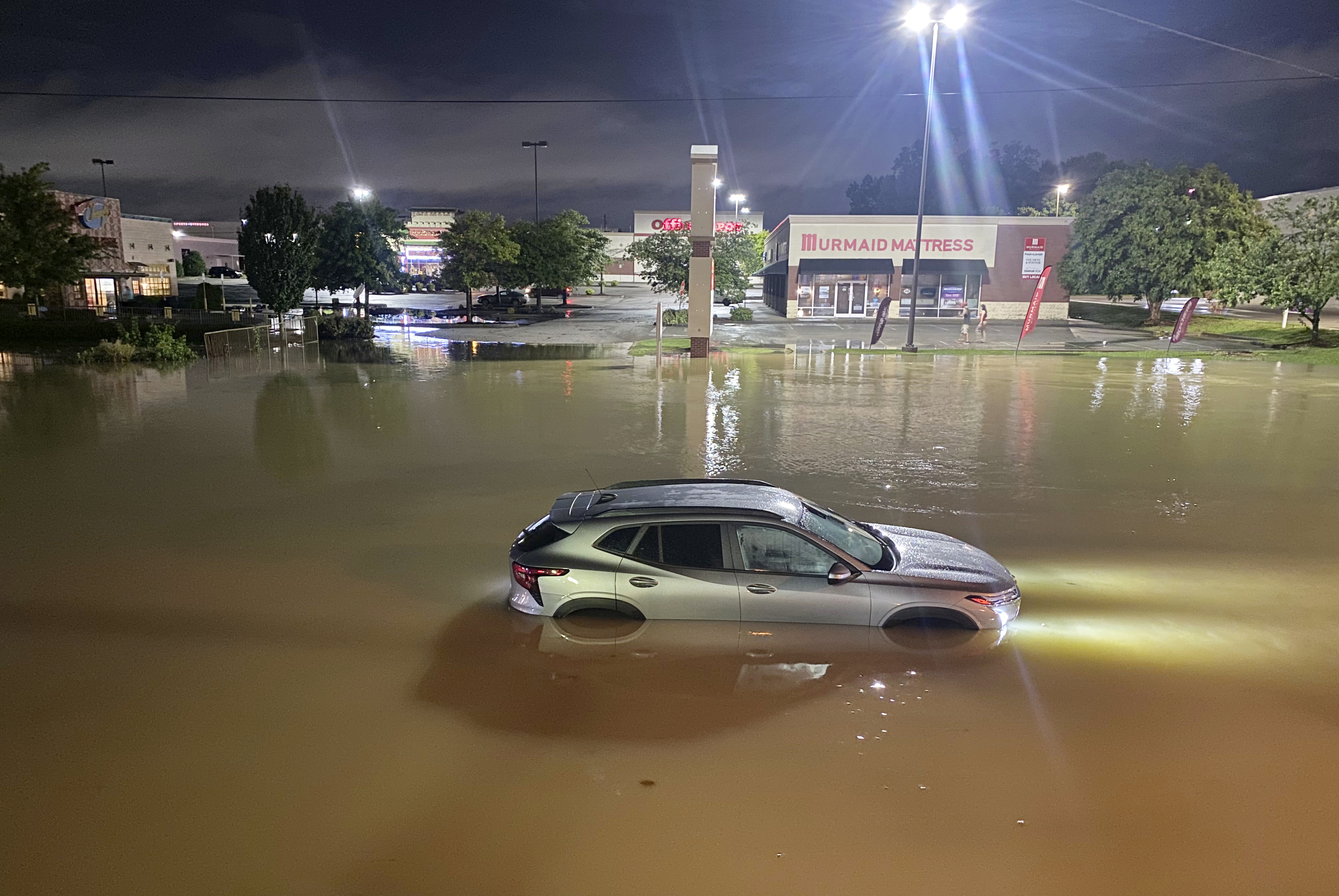 A car is stranded in floodwater on Gunbarrel Road, in Chattanooga, Tenn., on Aug. 12, 2025. (Robin Rudd/Chattanooga Times Free Press via AP)