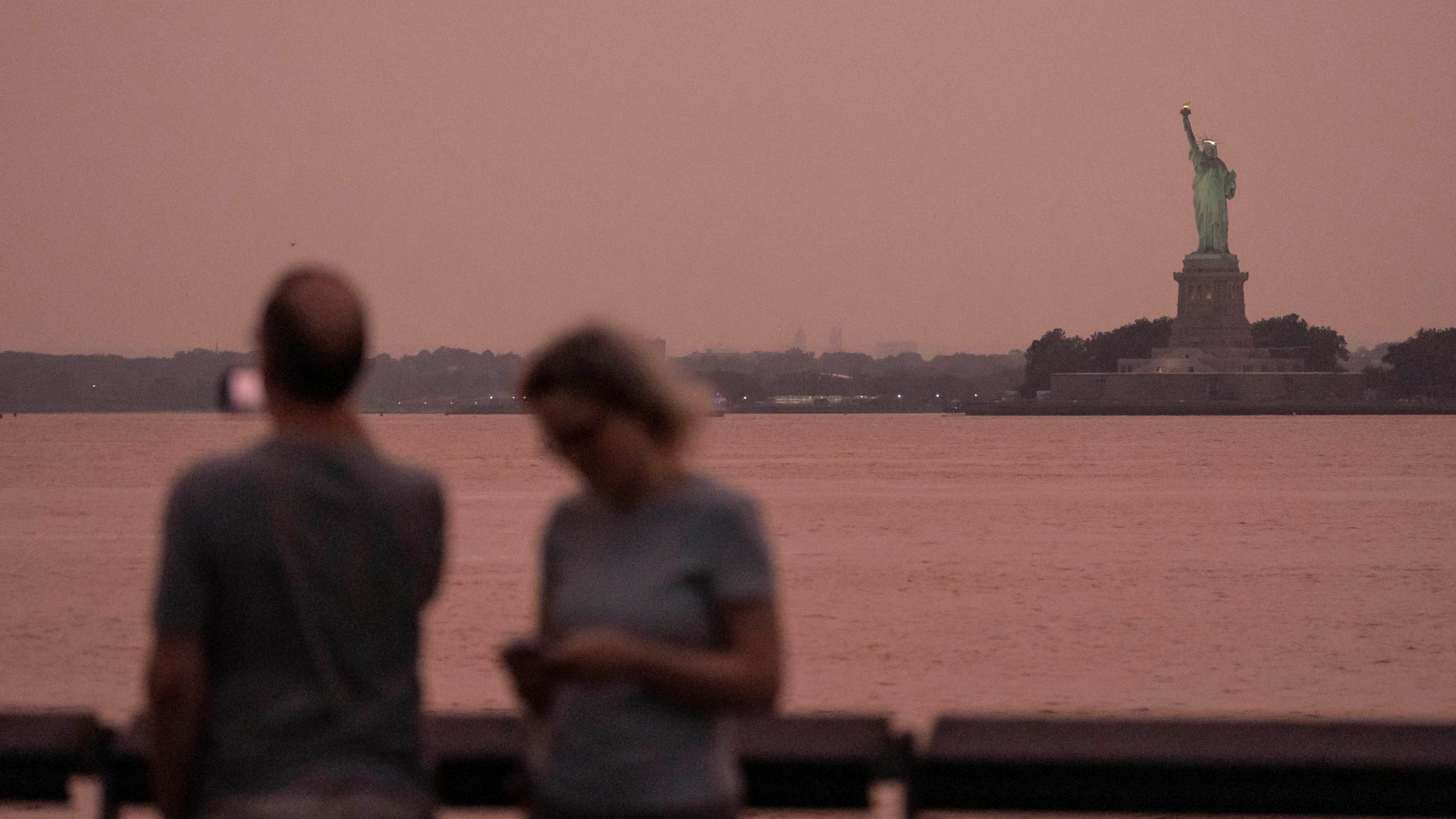 FILE - The Statue of Liberty is visible through haze due to Canadian wildfire smoke during sunset Aug. 5, 2025, in New York. (AP Photo/Yuki Iwamura, File)