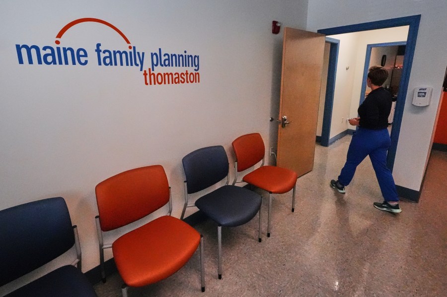 FILE - Vanessa Shields-Haas, a nurse practitioner, walks from the lobby toward the examination rooms at the Maine Family Planning healthcare facility, July 15, 2025, in Thomaston, Maine. (AP Photo/Charles Krupa)