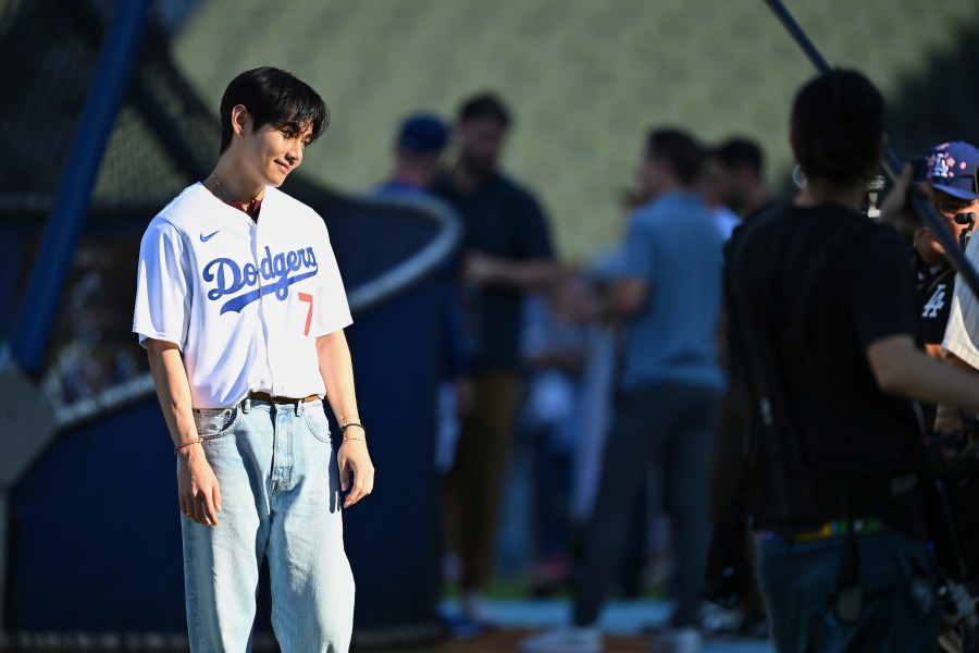 V, a member of the South Korean K-pop band BTS, looks on during batting practice before a baseball game between the Los Angeles Dodgers and the Cincinnati Reds Monday, Aug. 25, 2025, in Los Angeles. (AP Photo/Jayne Kamin-Oncea)