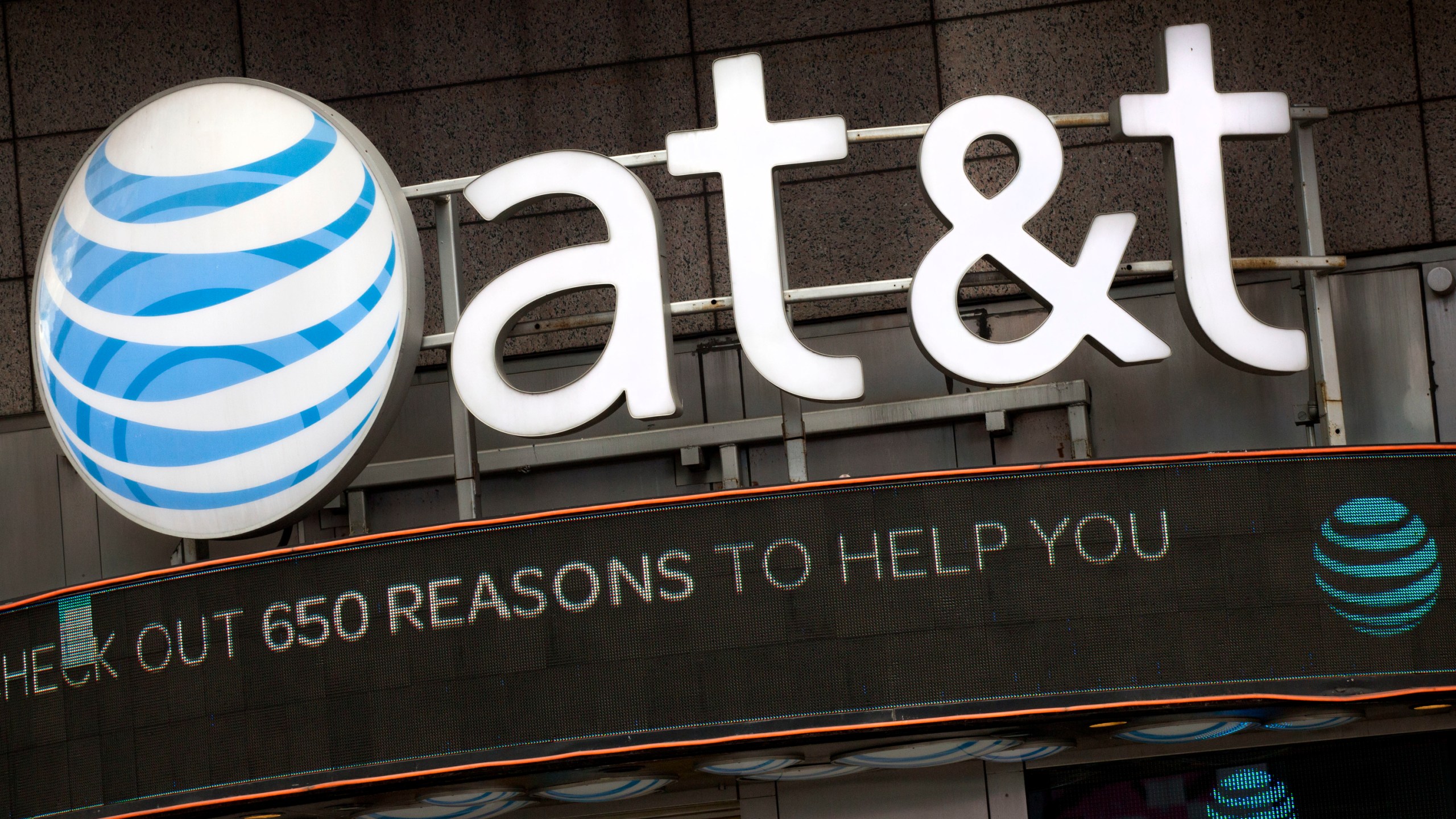 FILE - In this Oct. 24, 2016, file photo, the AT&T logo is positioned above one of its retail stores, in New York. (AP Photo/Mark Lennihan, File)
