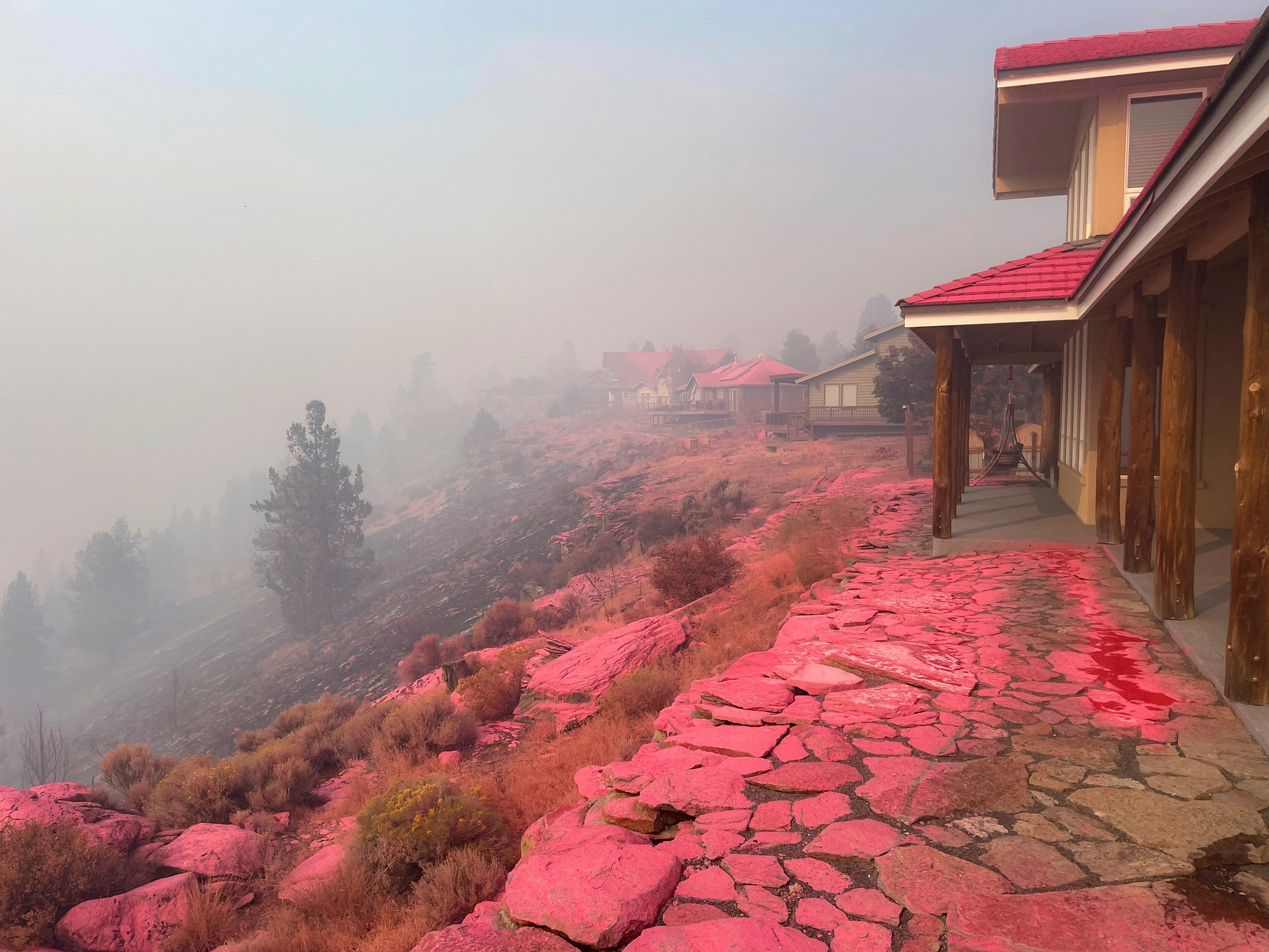 Deschutes County Sheriff's Office shows shows homes covered in fire retardant dropped from firefighting aircraft for battling the Flat Fire in central Oregon, Sunday, Aug. 24, 2025. (Deschutes County Sheriff's Office via AP)