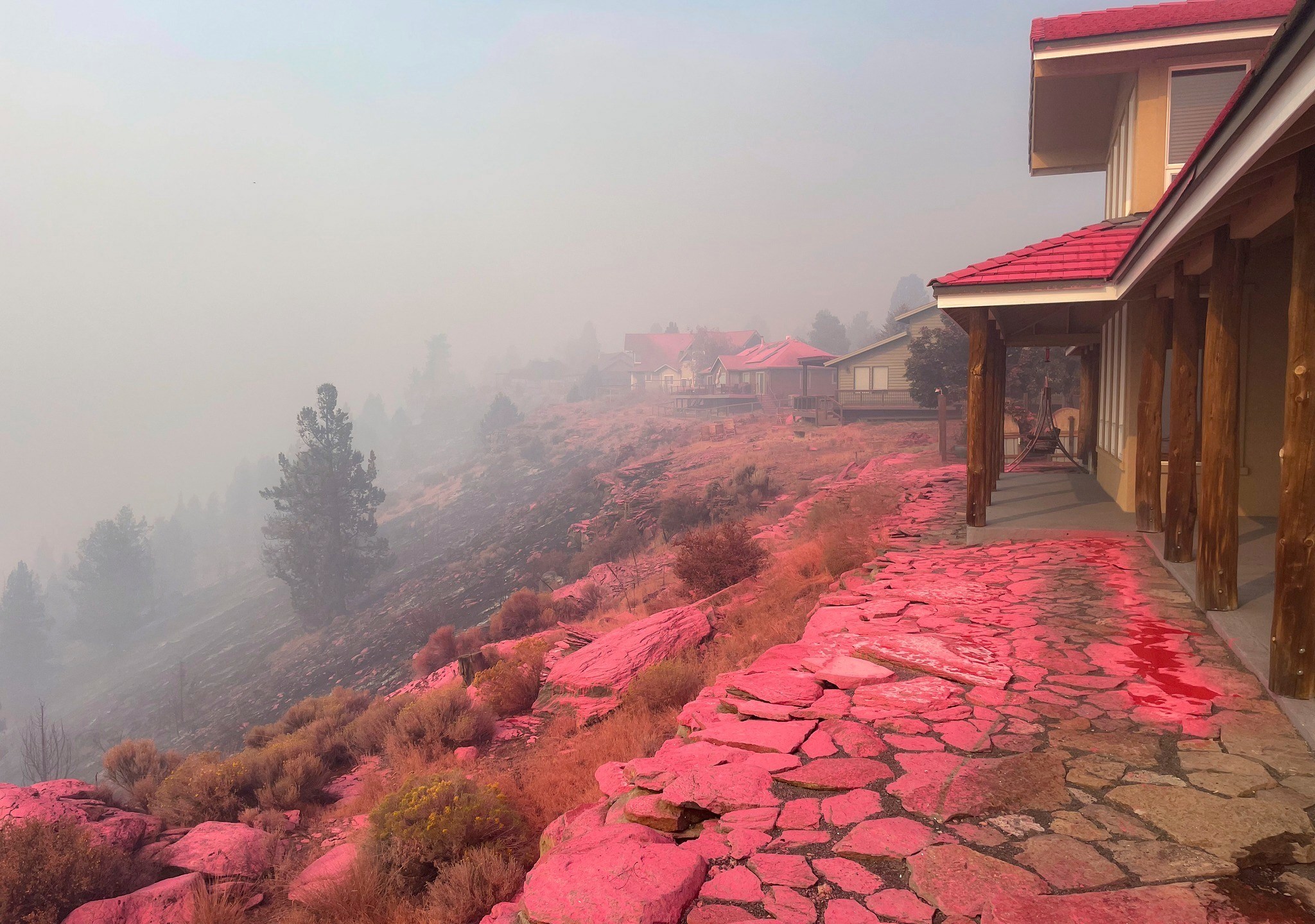 Deschutes County Sheriff's Office shows shows homes covered in fire retardant dropped from firefighting aircraft for battling the Flat Fire in central Oregon, Sunday, Aug. 24, 2025. (Deschutes County Sheriff's Office via AP)