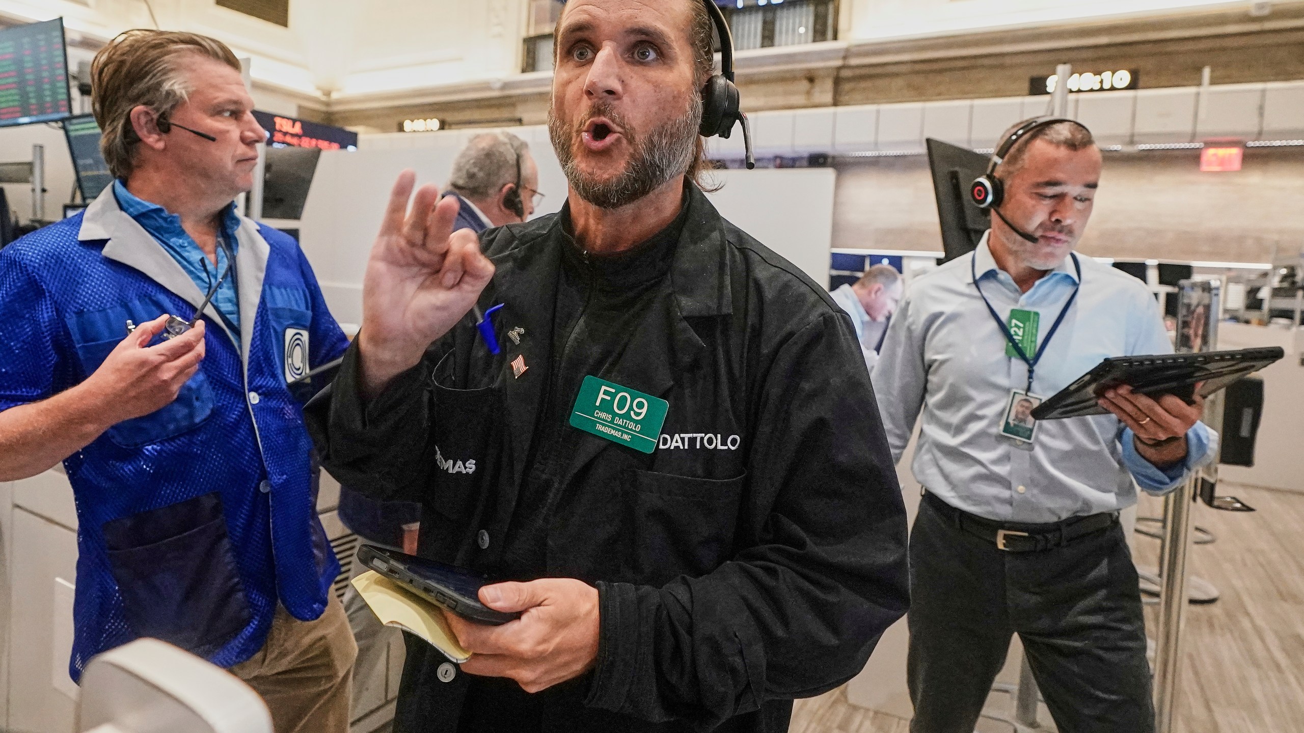 Options trader Chris Dattolo, center, works with colleagues on the floor of the New York Stock Exchange, Monday, Aug. 18, 2025. (AP Photo/Richard Drew)