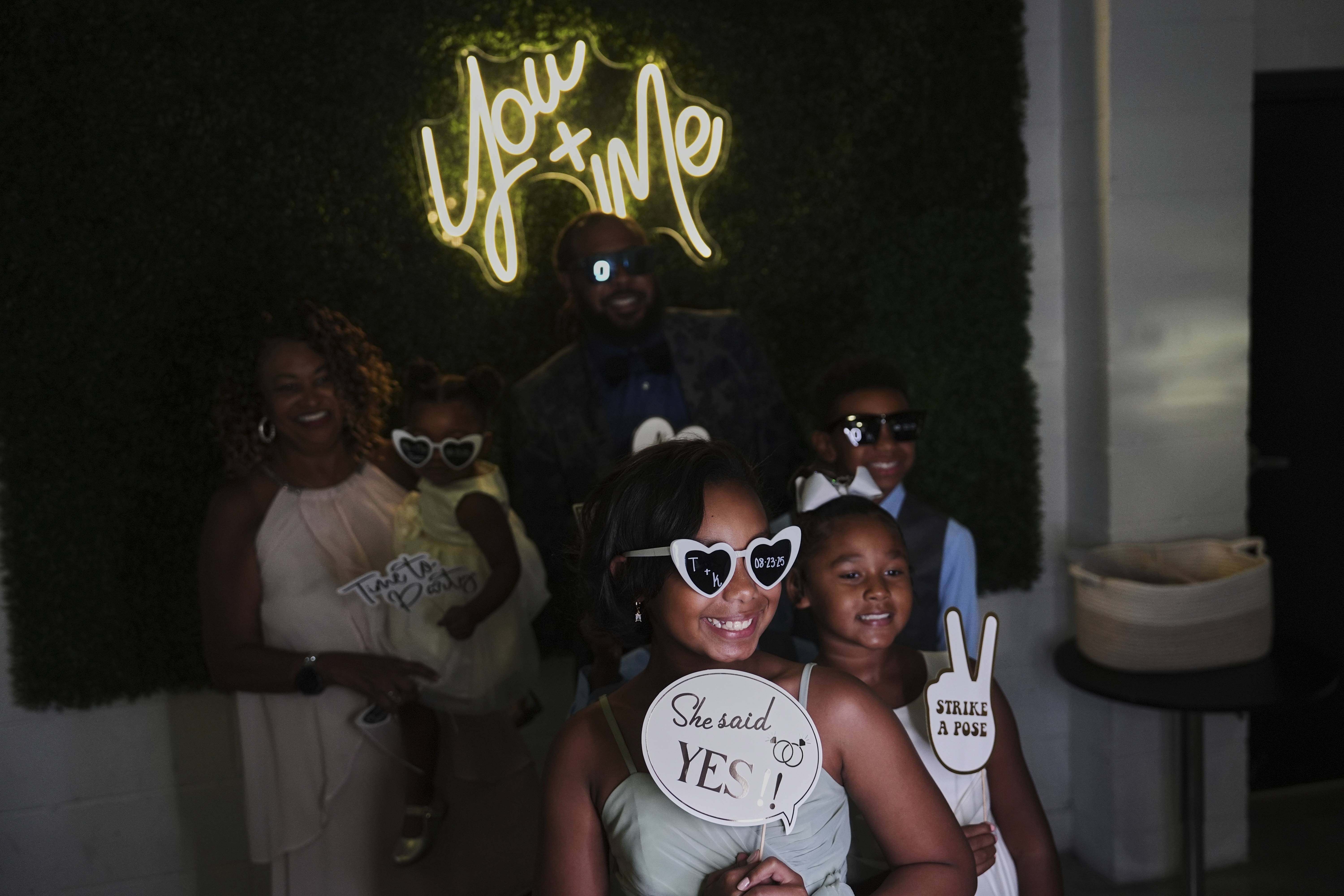 Bridesmaid Dakota-Jade Jones, front center, poses in a photo booth during a wedding reception Saturday, Aug. 23, 2025, in Newtown, Ohio. (AP Photo/Joshua A. Bickel)