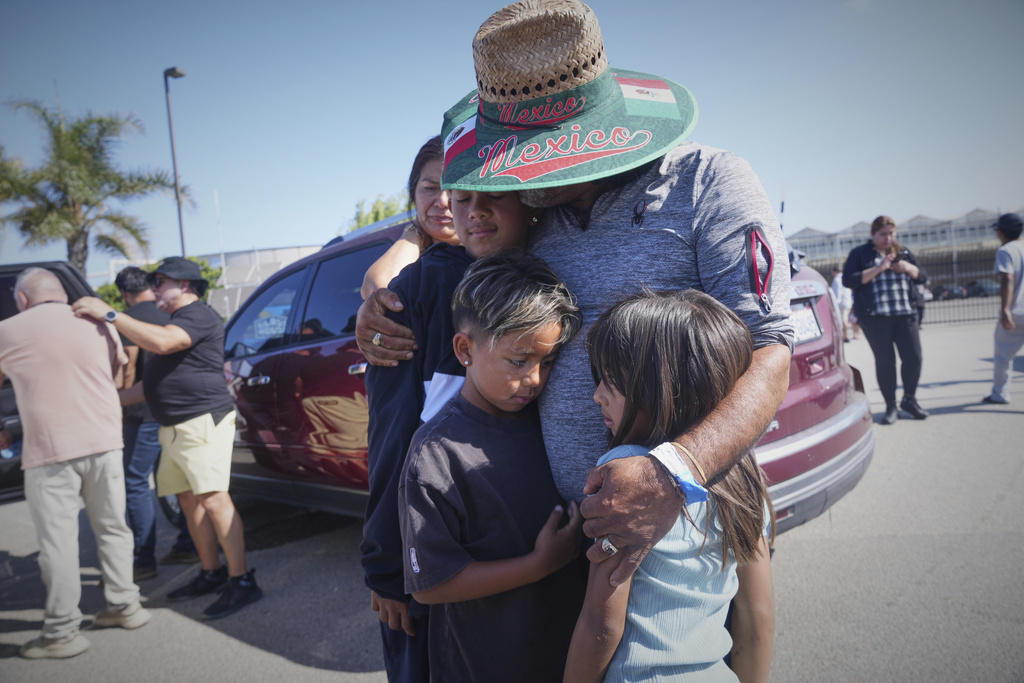 People embrace outside of Glass House Farms, a day after an immigration raid on the facility, on July 11, 2025, in Camarillo. (AP Photo)
