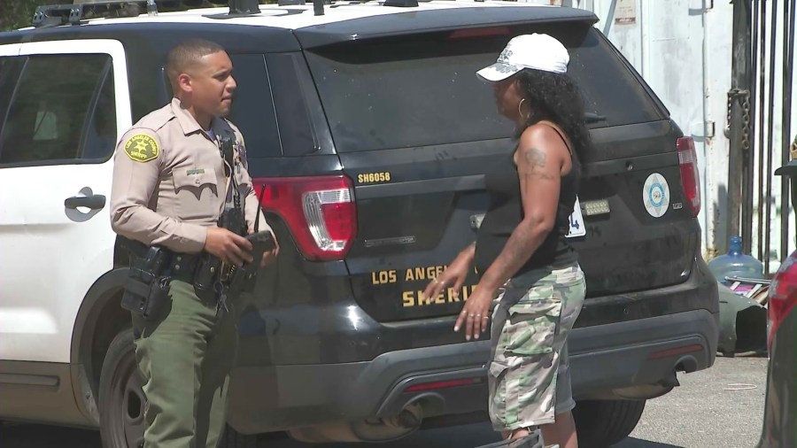 The cemetery’s owner, Celestina Bishop, is seen speaking with a Los Angeles County sheriff's deputy about the crimes after finding a crowbar she believed a thief left behind. (KTLA)
