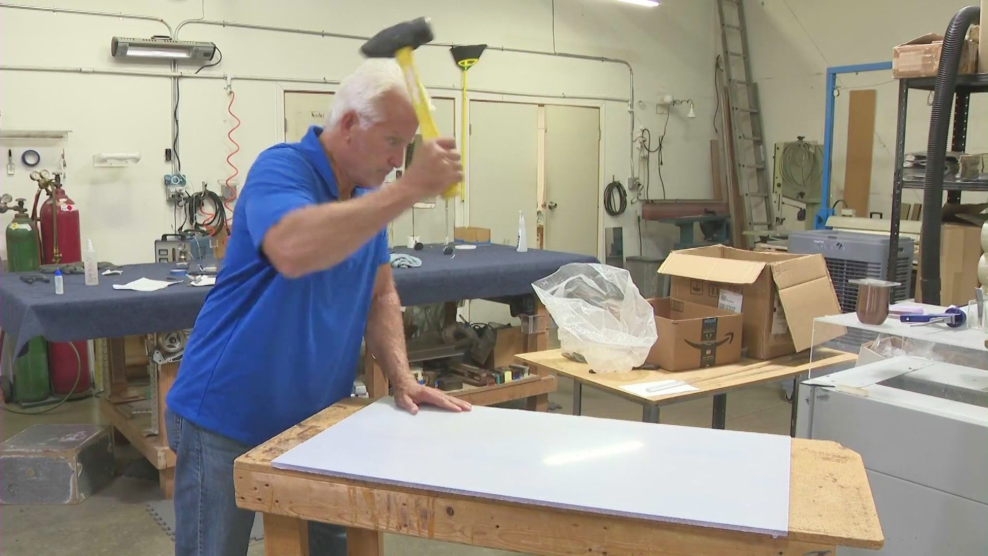 KTLA's Rick Chambers attempts to smash the unbreakable glass sheet, but is unsuccessful. (KTLA)