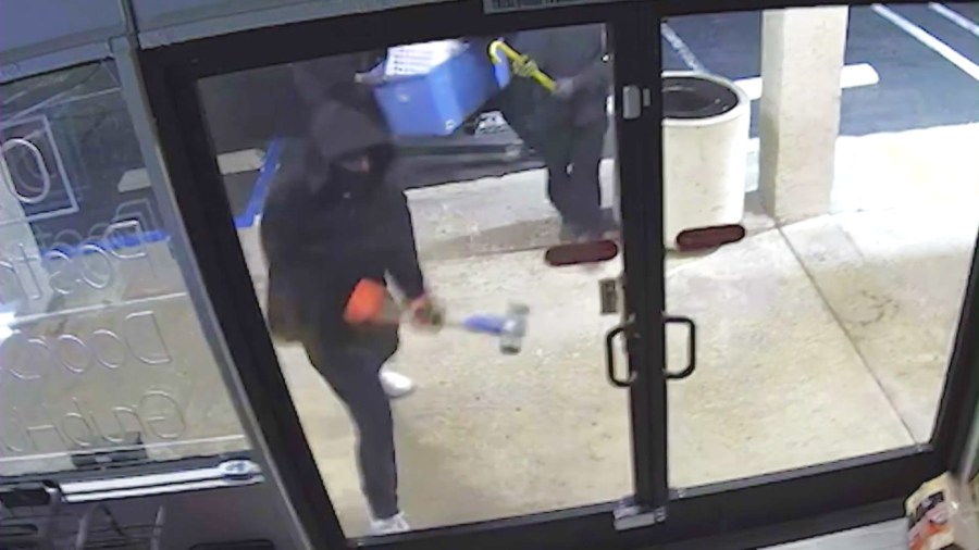 A suspect attempts to smash an unbreakable glass installed on a shop's front doors, but fails to break it with a hammer.