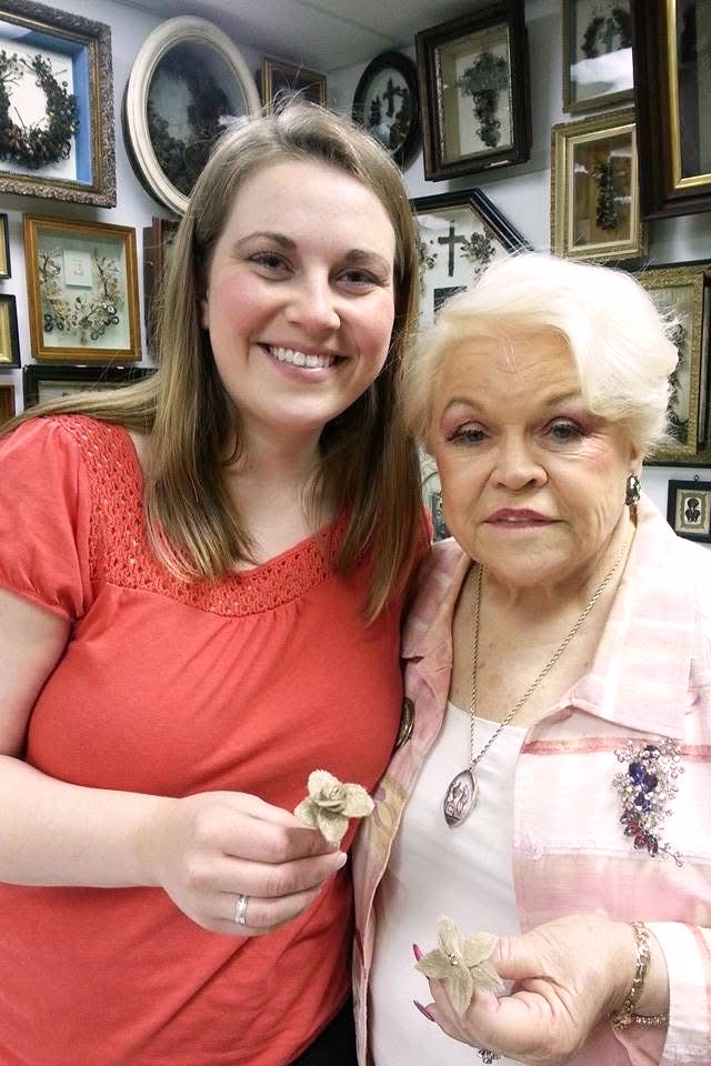 In this photo provided by Lindsay Evans, Evans and her grandmother, Leila Cohoon, hold hair flowers made from Evans' son's hair at Leila’s Hair Museum in Independence, Miss. (Lindsay Evans via AP)
