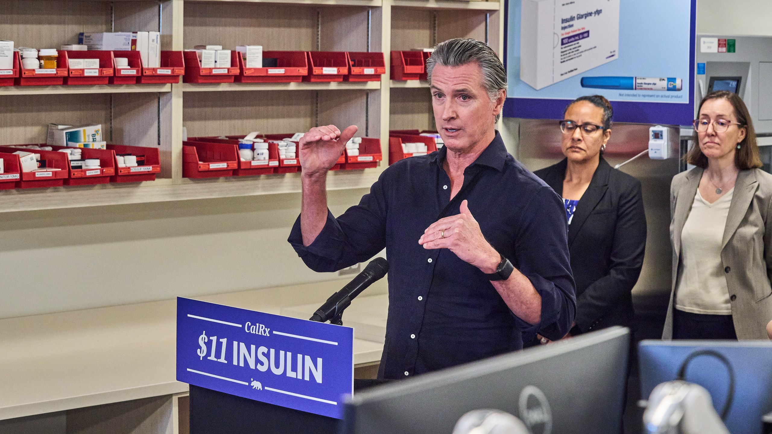 California Gov. Gavin Newsom announces CalRx-branded insulin glargine pens available next Jan. 1, 2026, at a suggested retail price of no more than $55 per five-pack, or $11 per pen, during a news conference at Cedar-Sinai's Mark Goodson pharmacy in Los Angeles Thursday, Oct. 16, 2025. Secretary Kim Johnson, Cal HHS Agency, middle. (AP Photo/Damian Dovarganes)