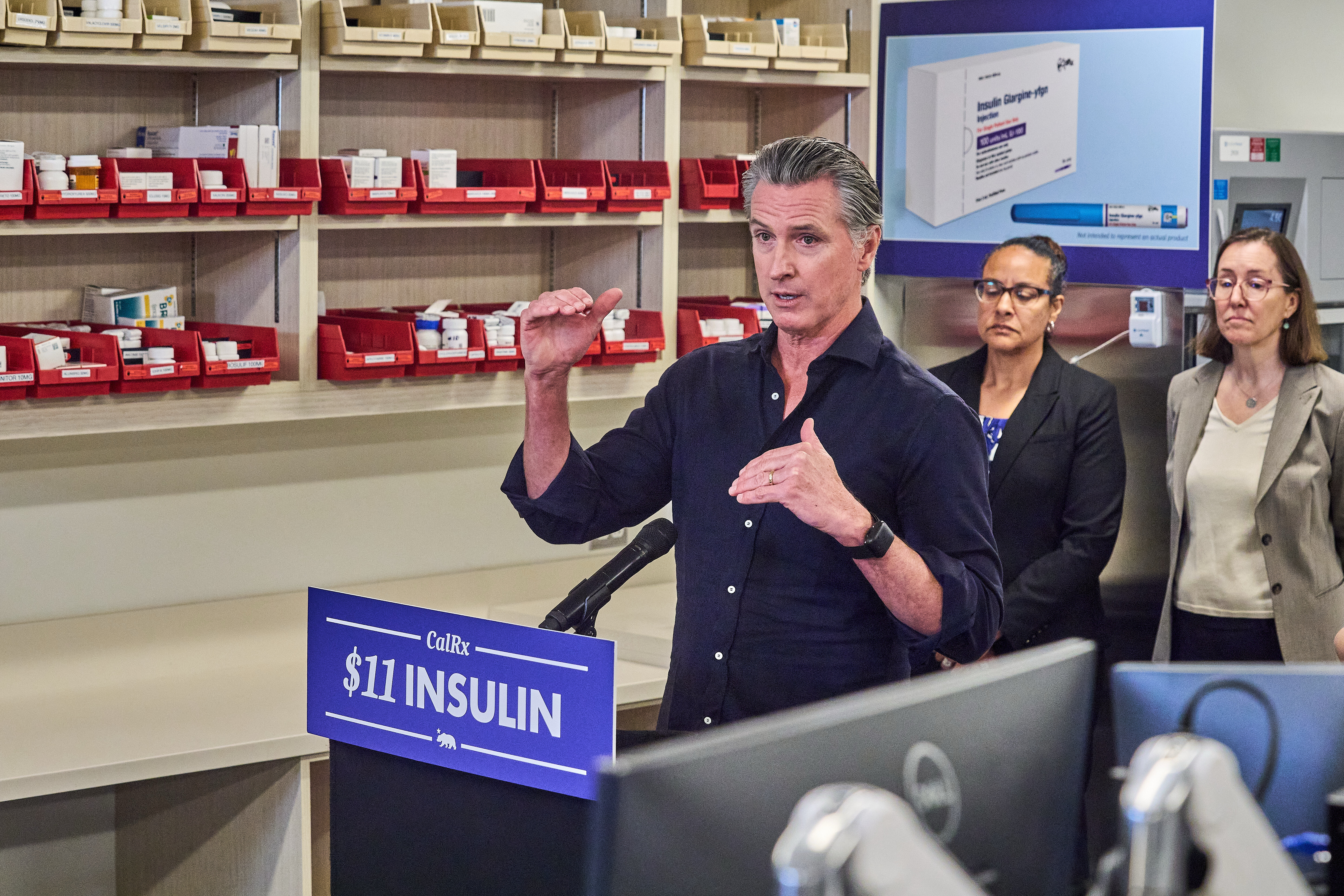 California Gov. Gavin Newsom announces CalRx-branded insulin glargine pens available next Jan. 1, 2026, at a suggested retail price of no more than $55 per five-pack, or $11 per pen, during a news conference at Cedar-Sinai's Mark Goodson pharmacy in Los Angeles Thursday, Oct. 16, 2025. Secretary Kim Johnson, Cal HHS Agency, middle. (AP Photo/Damian Dovarganes)