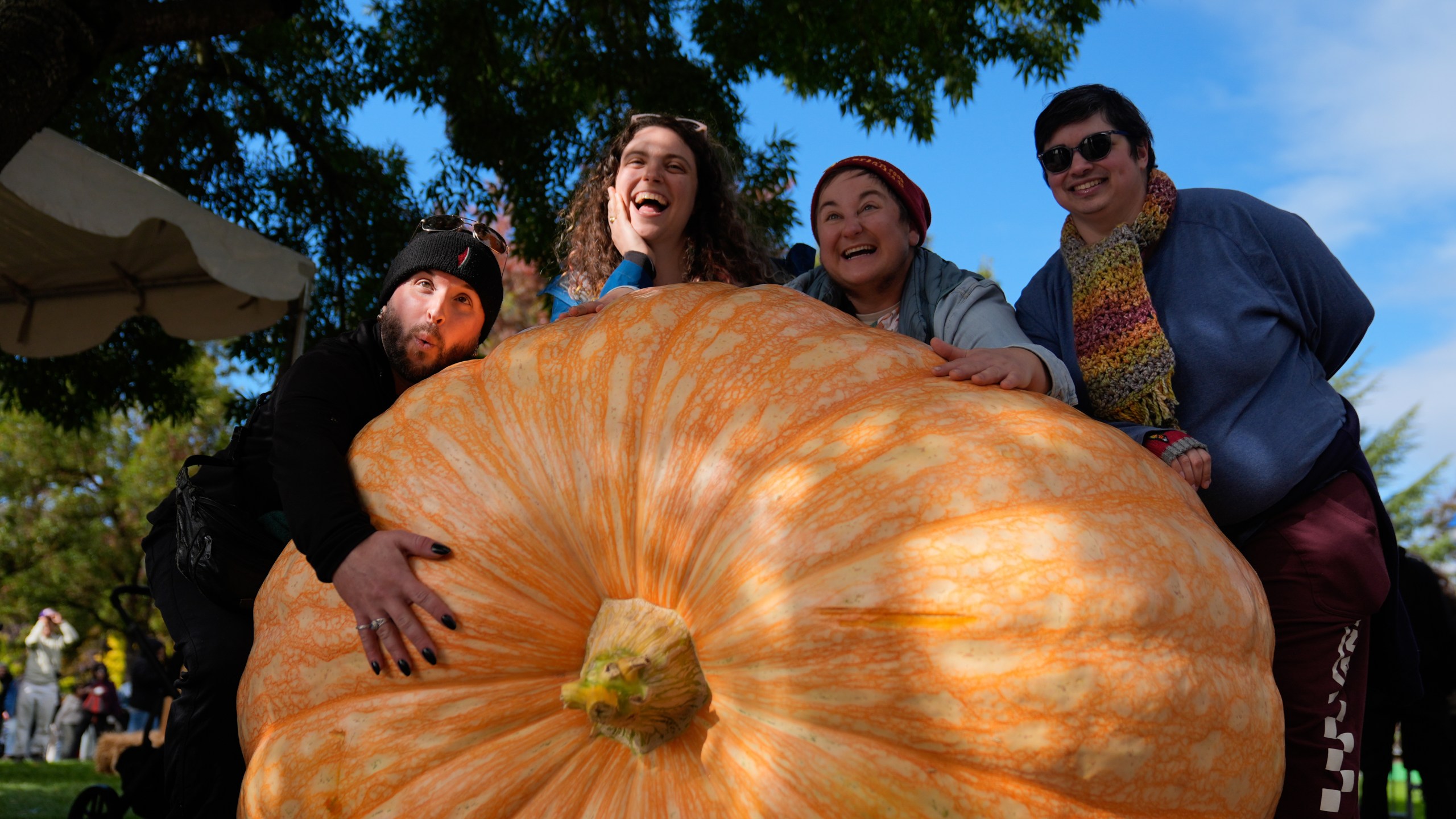 From left, Brod Salo, Julia, Rae Nathanson and Ellis Lorant pose with a giant pumpkin during the West Coast Giant Pumpkin Regatta on Sunday, Oct. 19, 2025, in Tualatin, Ore. (AP Photo/Jenny Kane)
