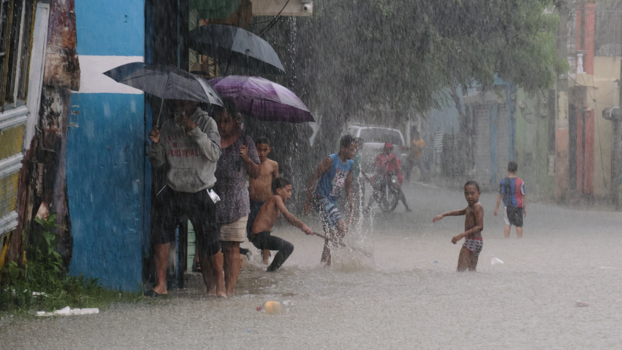 Children play in a street flooded by rains caused by Tropical Storm Melissa in Santo Domingo, Dominican Republic, Friday, Oct. 24, 2025. (AP Photo/Ricardo Hernandez)