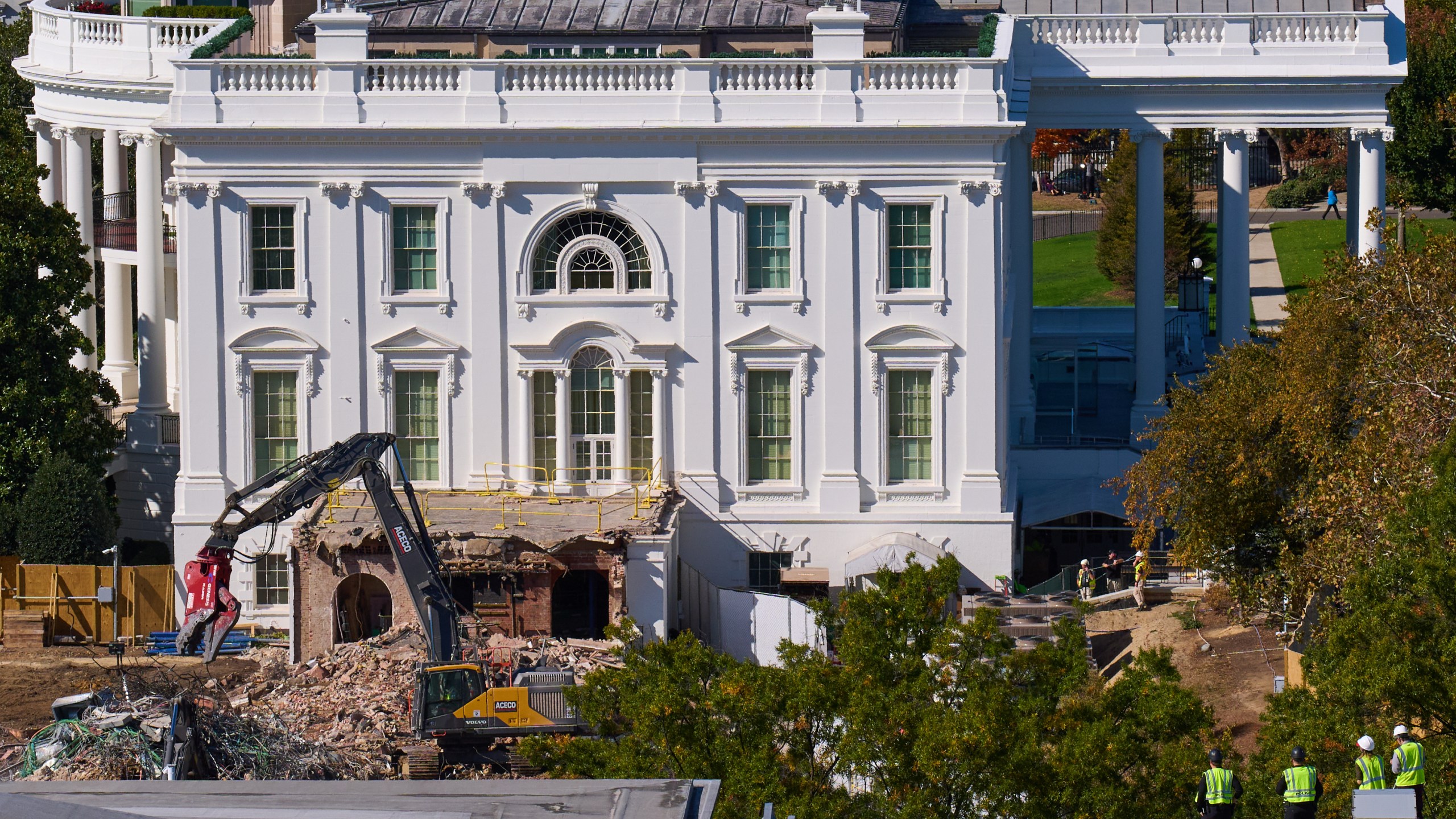 Construction workers, bottom right, atop the U.S. Treasury, watch watch as demolition continues on the East Wing of the White House to make room for a new ballroom, in Washington, Oct. 22, 2025. (AP Photo/Jacquelyn Martin)