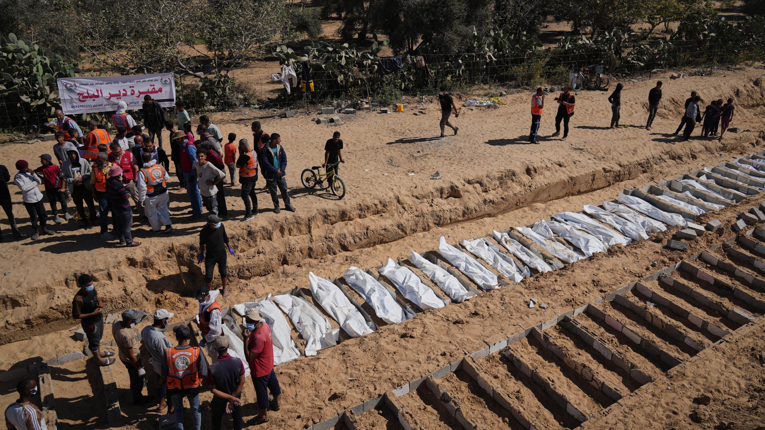 Bodies of unidentified Palestinians returned from Israel are buried in a mass grave in Deir al-Balah, Gaza Strip, Monday, Oct. 27, 2025. (AP Photo/Jehad Alshrafi)