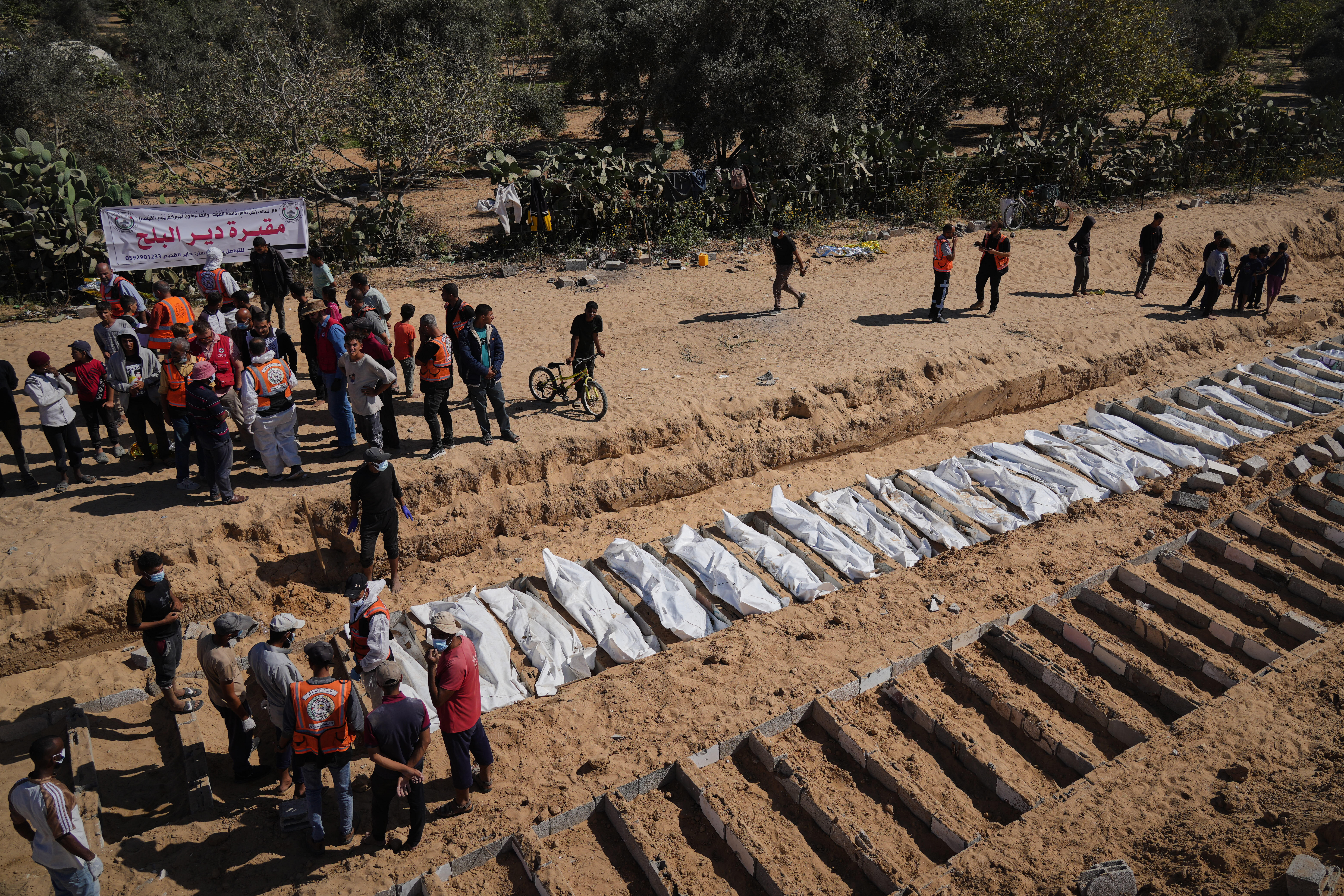 Bodies of unidentified Palestinians returned from Israel are buried in a mass grave in Deir al-Balah, Gaza Strip, Monday, Oct. 27, 2025. (AP Photo/Jehad Alshrafi)