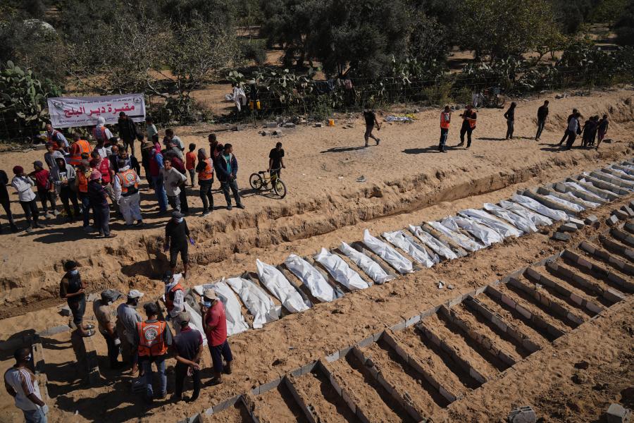 Bodies of unidentified Palestinians returned from Israel are buried in a mass grave in Deir al-Balah, Gaza Strip, Monday, Oct. 27, 2025. (AP Photo/Jehad Alshrafi)