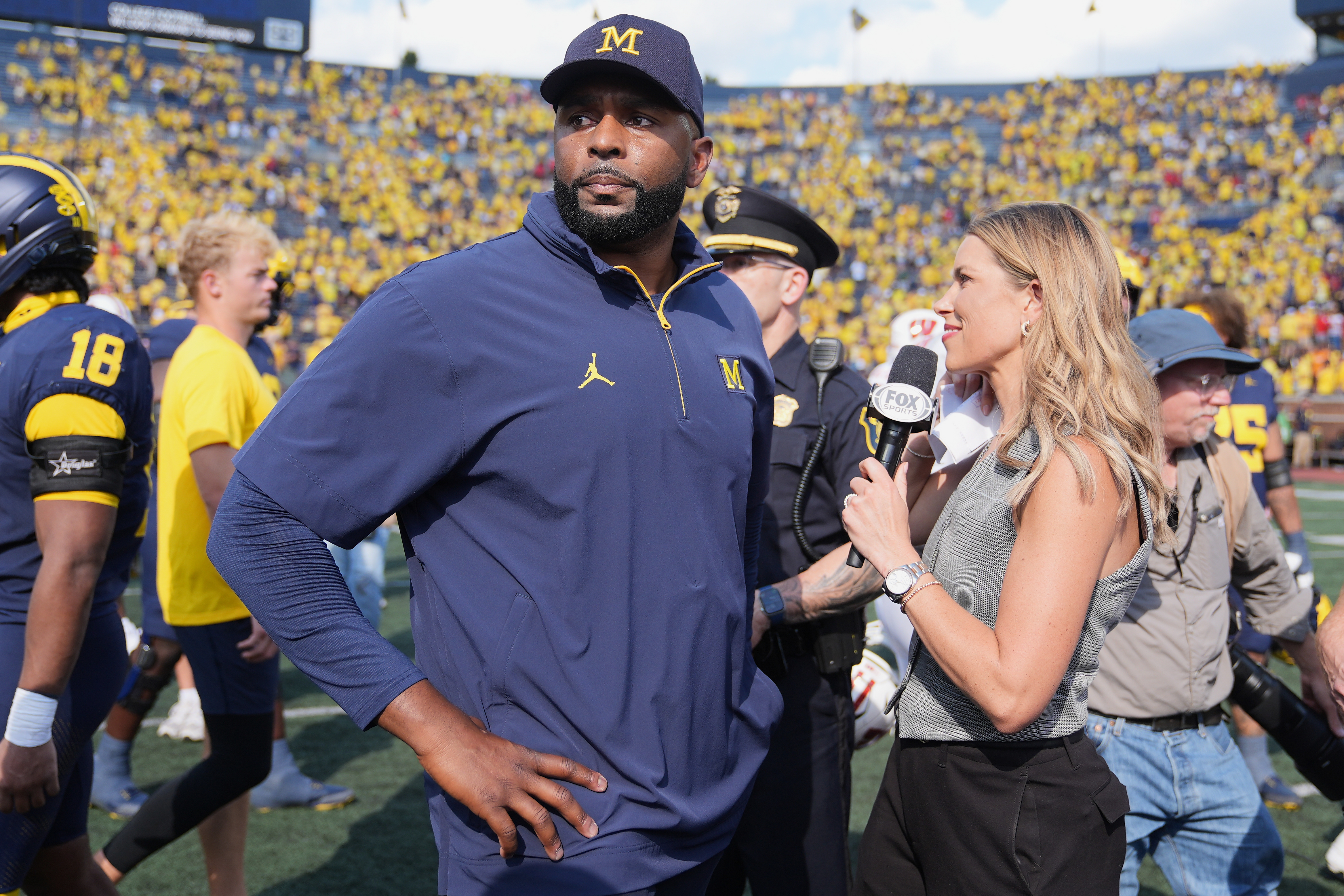 Michigan head coach Sherrone Moore gives a news interview after the team's win in an NCAA college football game against Wisconsin, Saturday, Oct. 4, 2025, in Ann Arbor, Mich. (AP Photo/Ryan Sun)