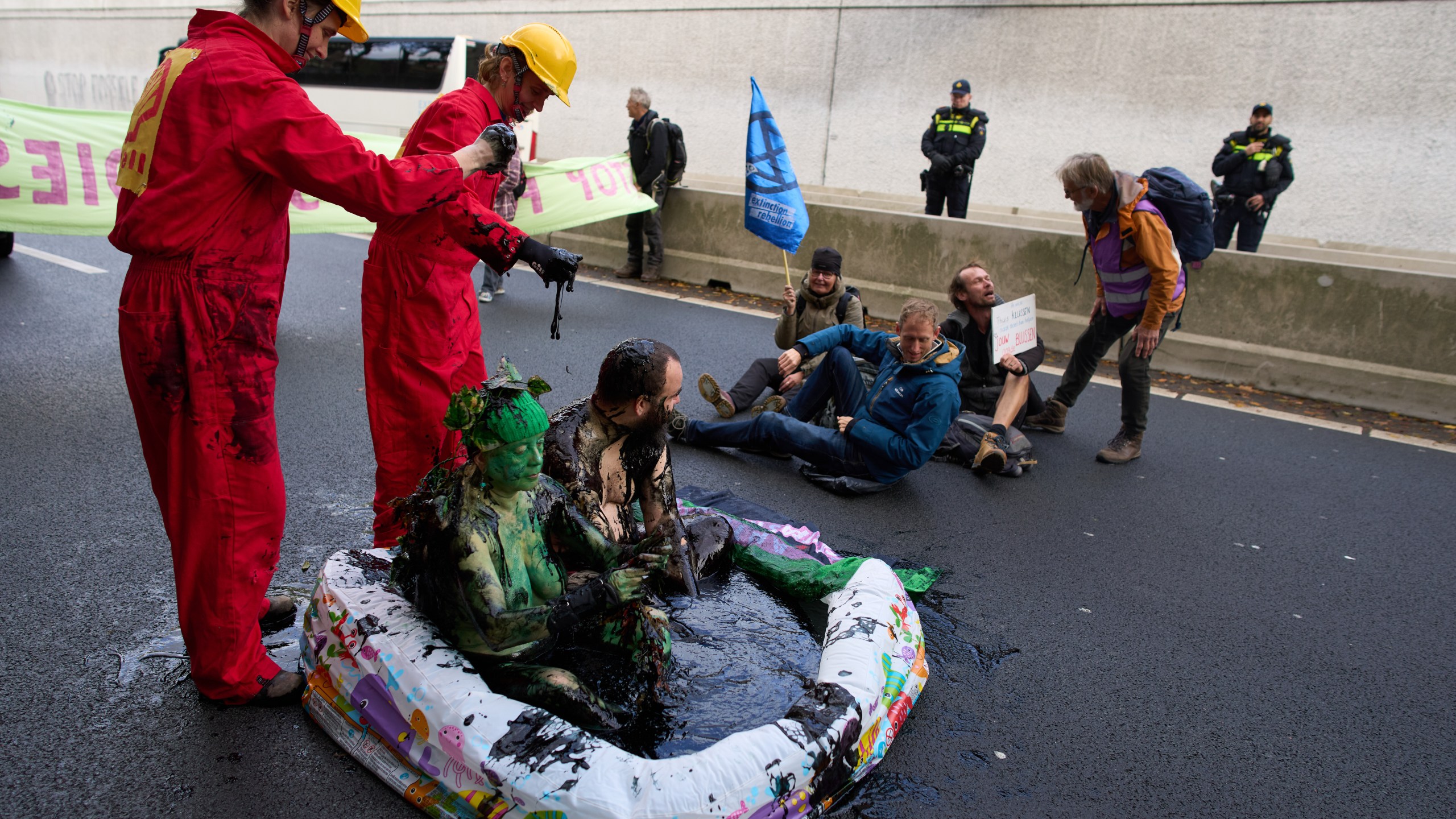 Extinction Rebellion demonstrators, some covered in oil, block a highway to protest fossil subsidies and new fossil fuel projects one day before the Oct. 29 general election, in The Hague, Netherlands, Tuesday, Oct. 28, 2025. (AP Photo/Peter Dejong)
