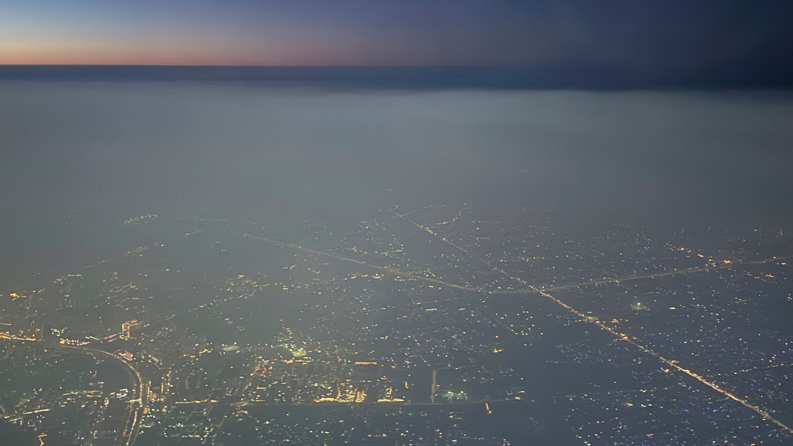A layer of smog hangs over the skyline as seen from an aircraft window in New Delhi, India, Saturday, Oct. 25, 2025. (AP Photo/Yirmiyan Arthur)