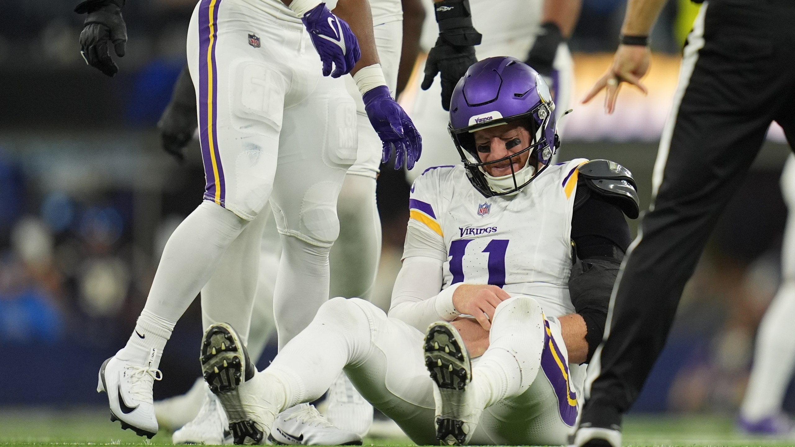 Minnesota Vikings quarterback Carson Wentz (11) sits on the ground after a hit during the second half of an NFL football game against the Los Angeles Chargers Thursday, Oct. 23, 2025, in Inglewood, Calif. (AP Photo/Gregory Bull)