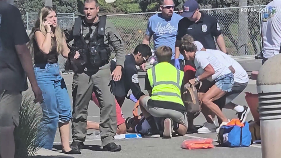 First responders providing medical aid to a victim after a helicopter crashed near a hotel in Huntington Beach on Oct. 11, 2025. (Rory Rausch)
