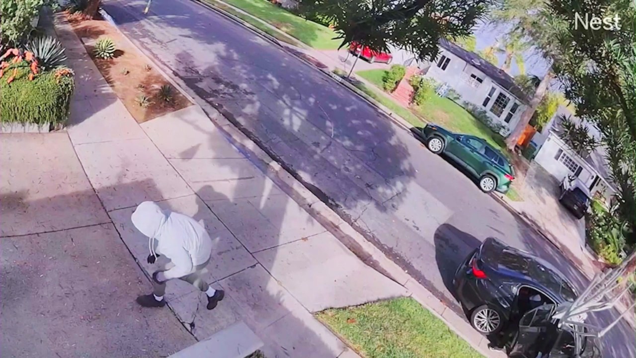 Three hooded, masked suspects are seen creeping up to the home and heading toward the backyard. (Lea Young)